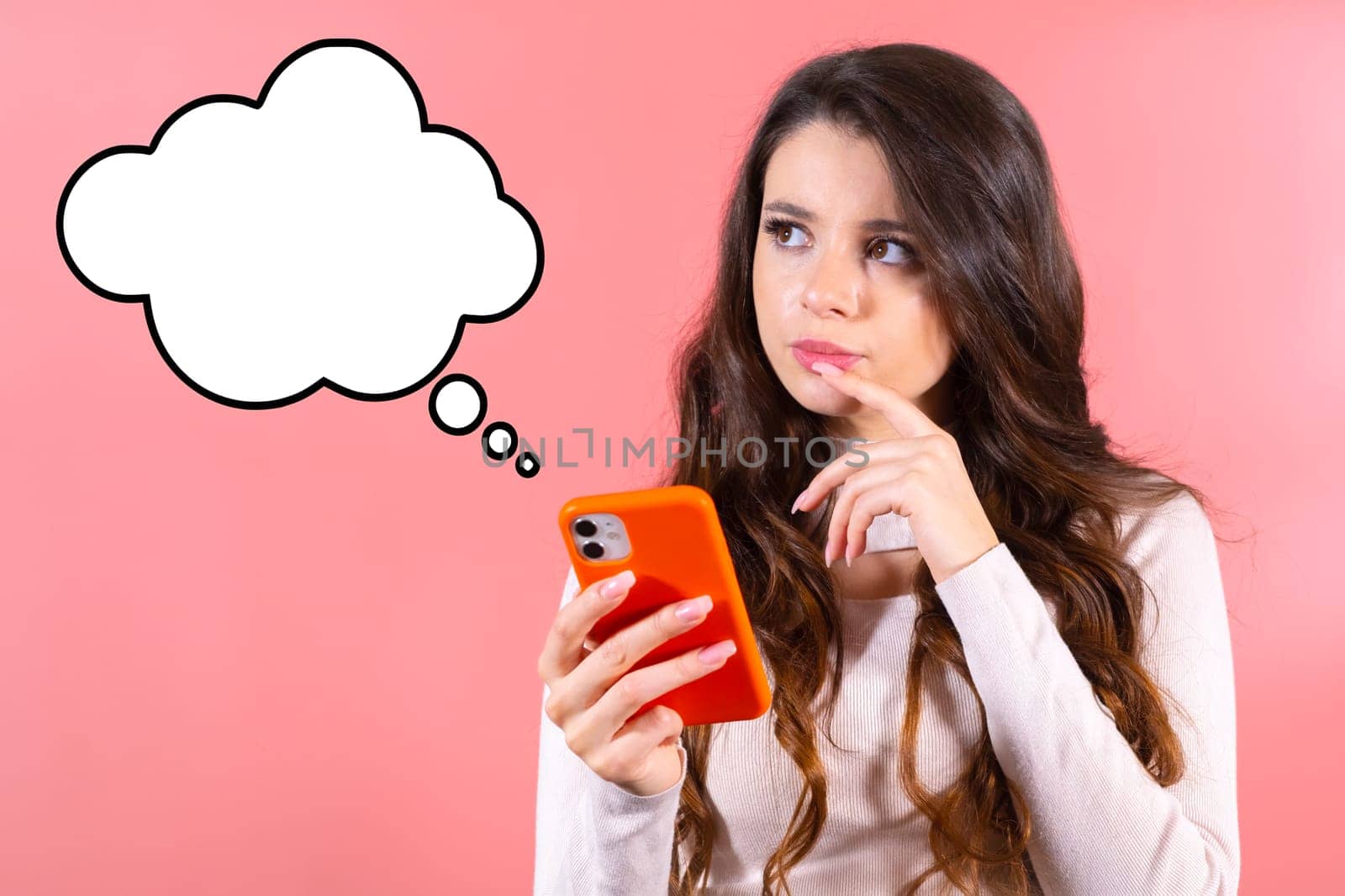Amazing lady looking up at the cloud for text, deep thinking and holding a mobile phone isolated on the pink background