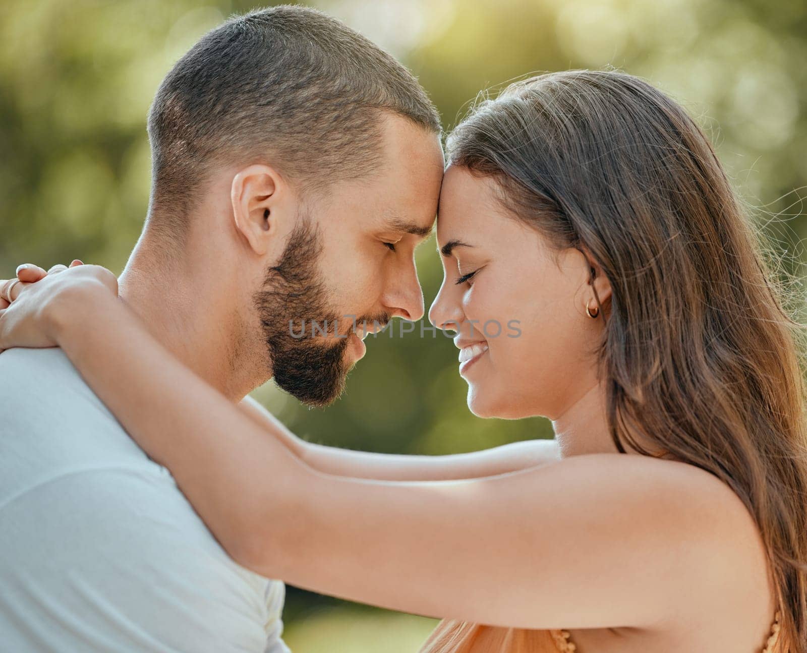 Couple, love and forehead touch in garden, summer park or outdoor backyard in Spain for care, happiness and easy lifestyle together. Smile, romance and date of man, woman and people in happy marriage.