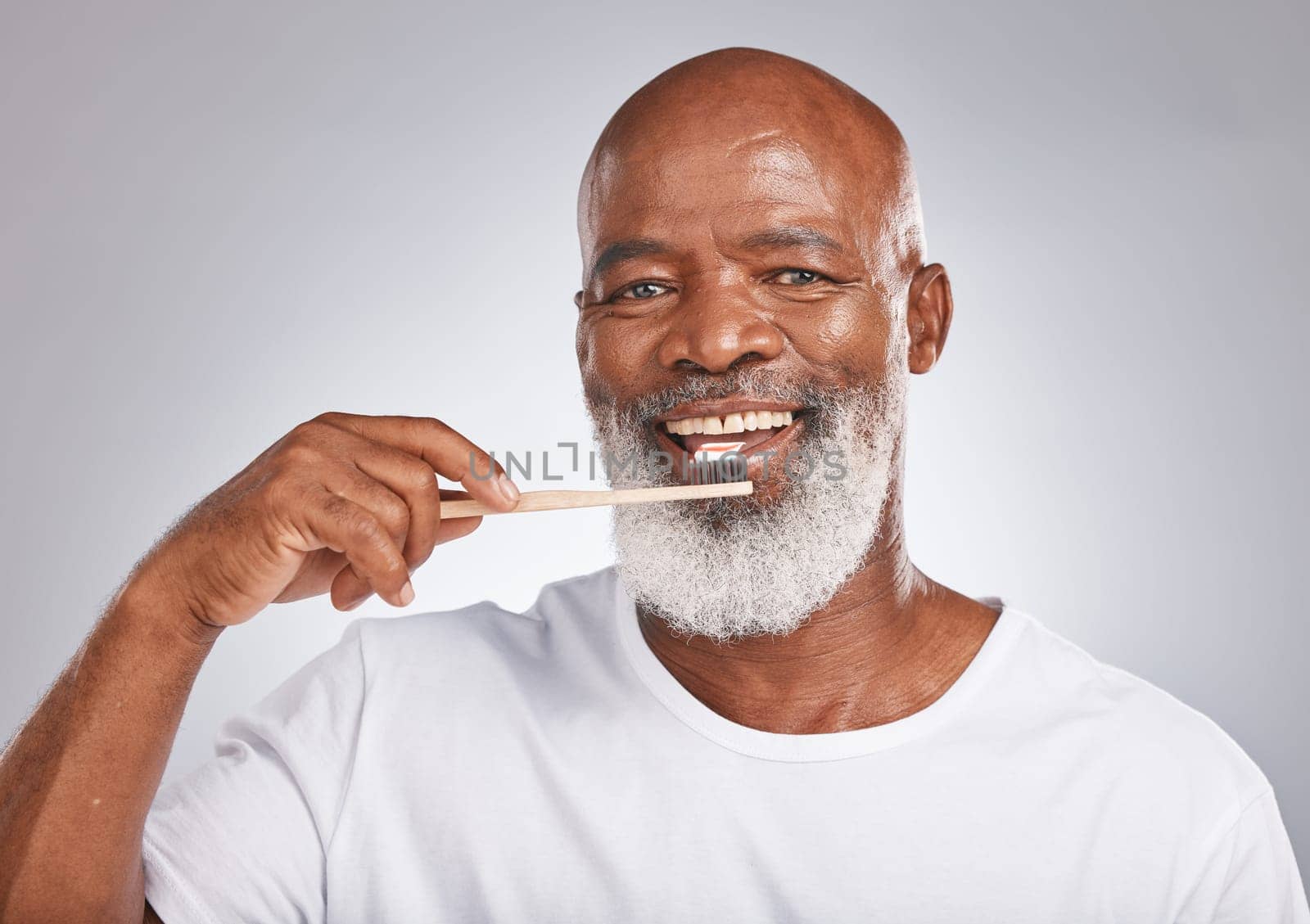 Brushing teeth, studio portrait and black man with toothbrush for mature dental wellness, healthy lifestyle or cleaning aesthetic in Nigeria. Happy face, male model and oral mouth care of fresh smile.
