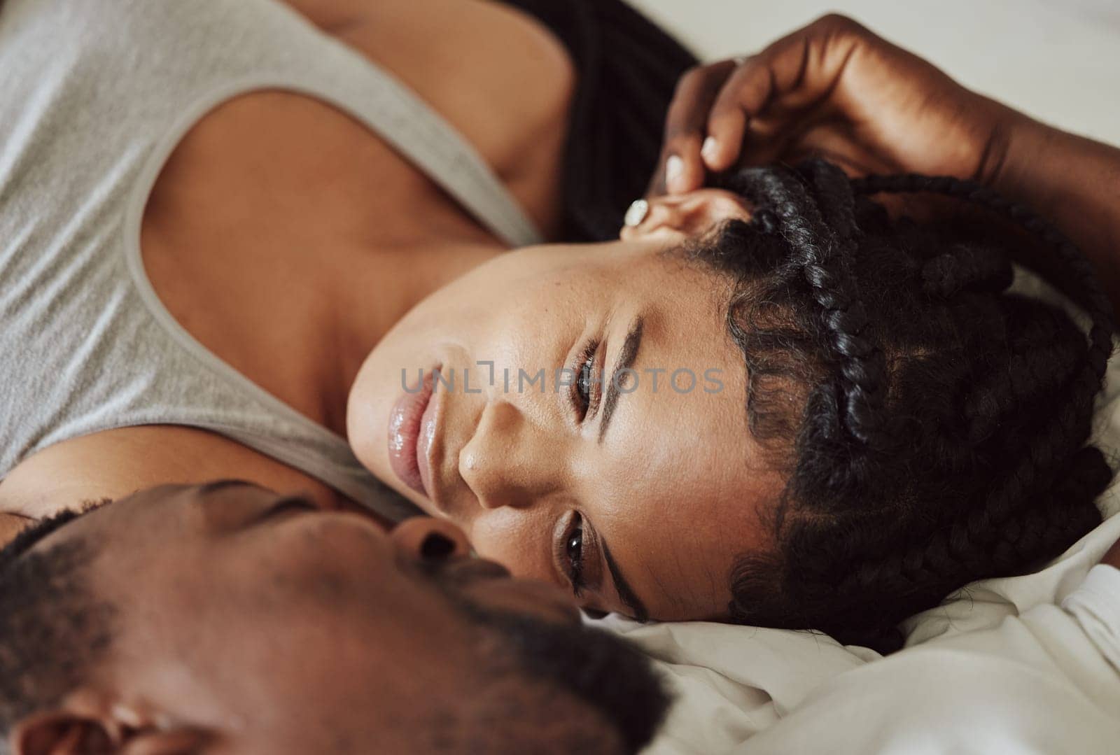 Black couple, love and bedroom romance while happy and intimate on a bed at home, apartment or hotel to relax. Face of a young man and woman in a happy marriage with commitment, trust and care by YuriArcurs