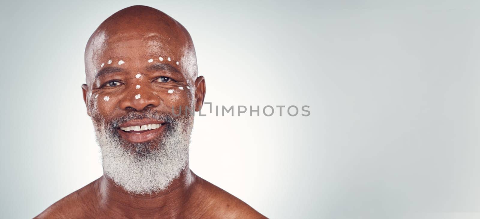 Skincare, portrait and senior man relax in studio with face cream, sunscreen and product on grey background. Facial, wrinkles and elderly model happy with skin, treatment and luxury cosmetics.