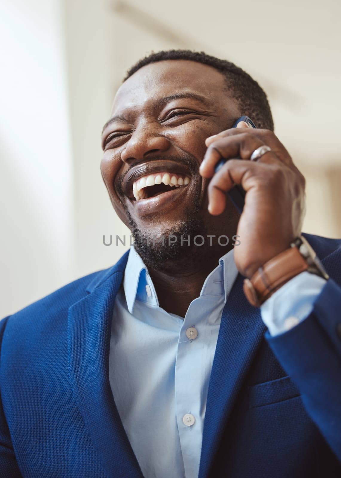 Phone call, communication and laughing with a business black man talking while working in corporate. Mobile, networking or management with a male CEO feeling happy while chatting on his smartphone.