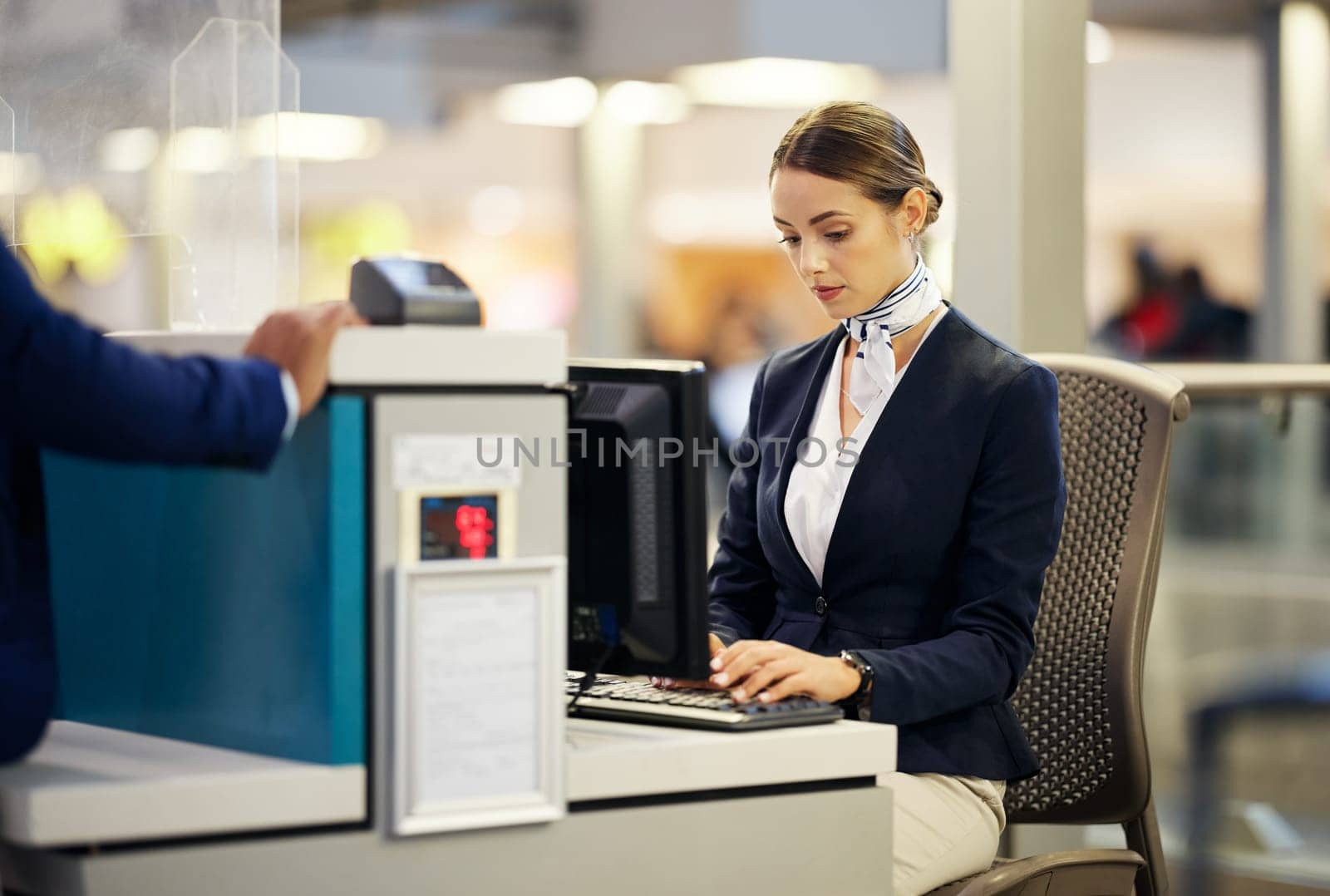 Airport, check in desk and woman typing for security, identity and travel documents for border immigration service. Concierge, customer service and help for global transportation with pc on table.