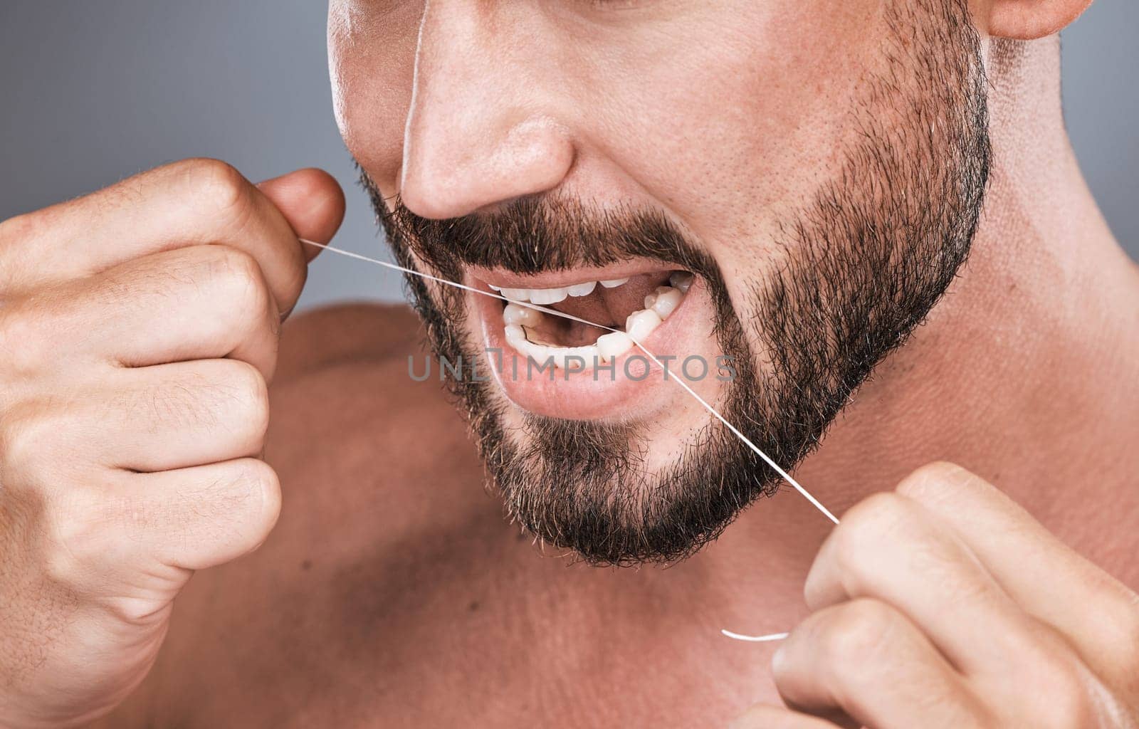 Mouth floss, tooth and man in studio for beauty, healthy body care and hygiene on background. Closeup of male, teeth flossing and cleaning face for facial wellness, fresh breath and dental cosmetics.