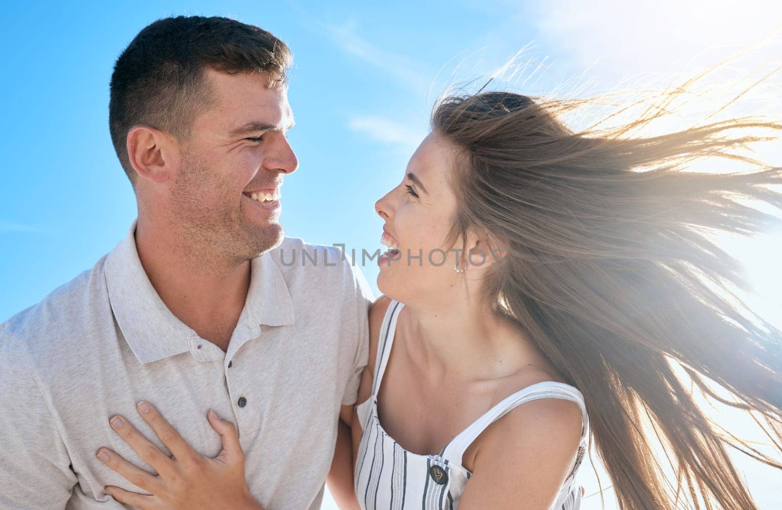 Couple, love and hug together in summer for travel adventure vacation outdoors. Excited woman, happy man and funny comedy conversation, romance bonding and quality time or support in sunshine.