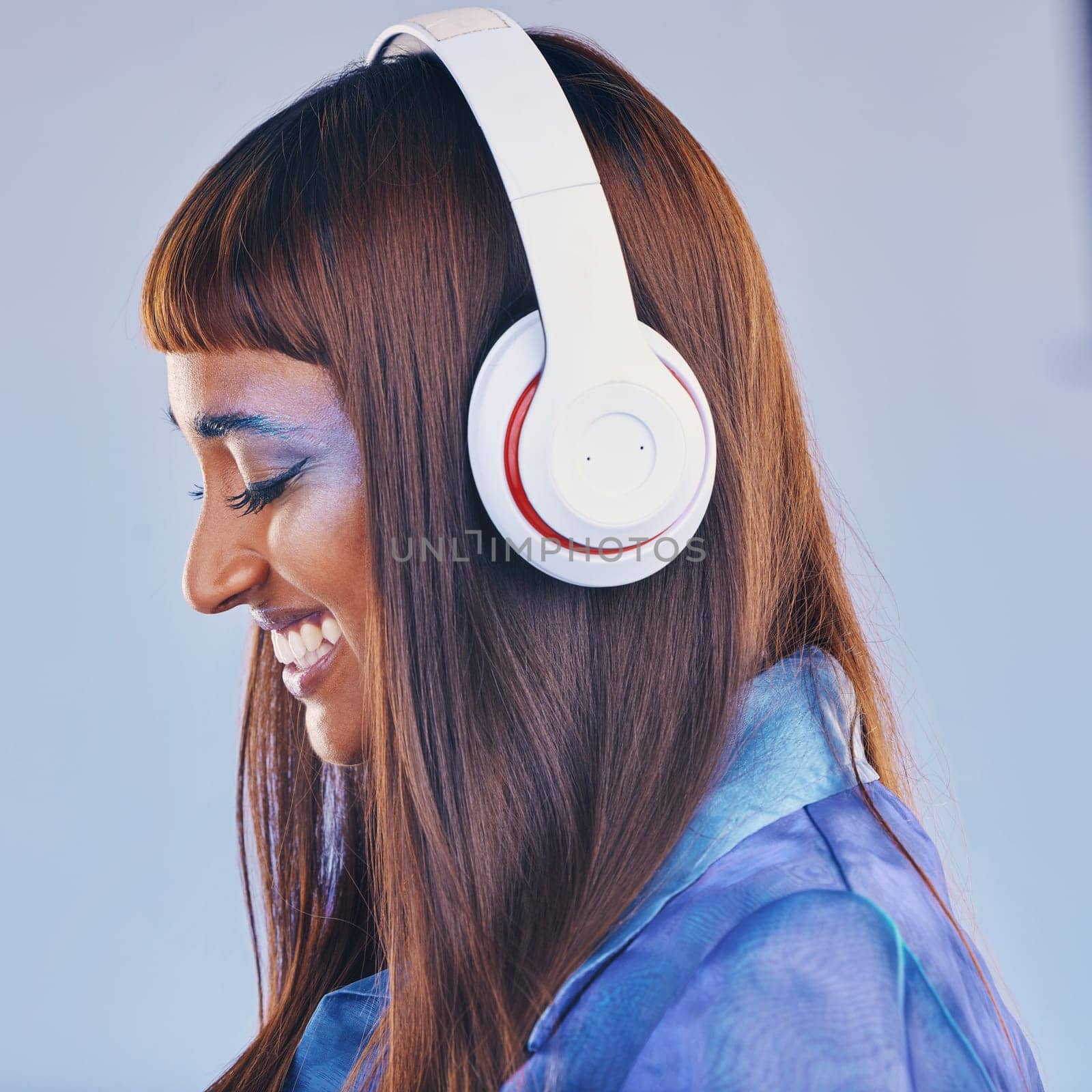 Headphones, music and black woman isolated on purple background for cyberpunk fashion and creative gen z. Young person or beauty model listening on audio technology, pop art and cosmetics in studio.