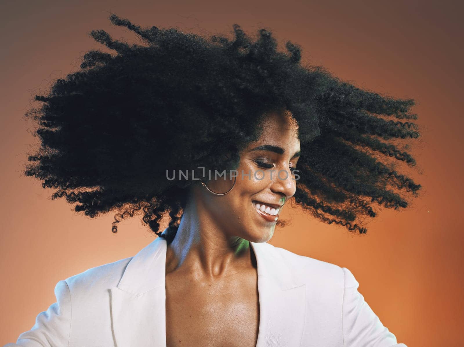 Natural hair, beauty and black woman with hair care, cosmetics and happiness against studio background. Makeup, dance and freedom with pride in curly hair texture and wellness in skincare headshot.