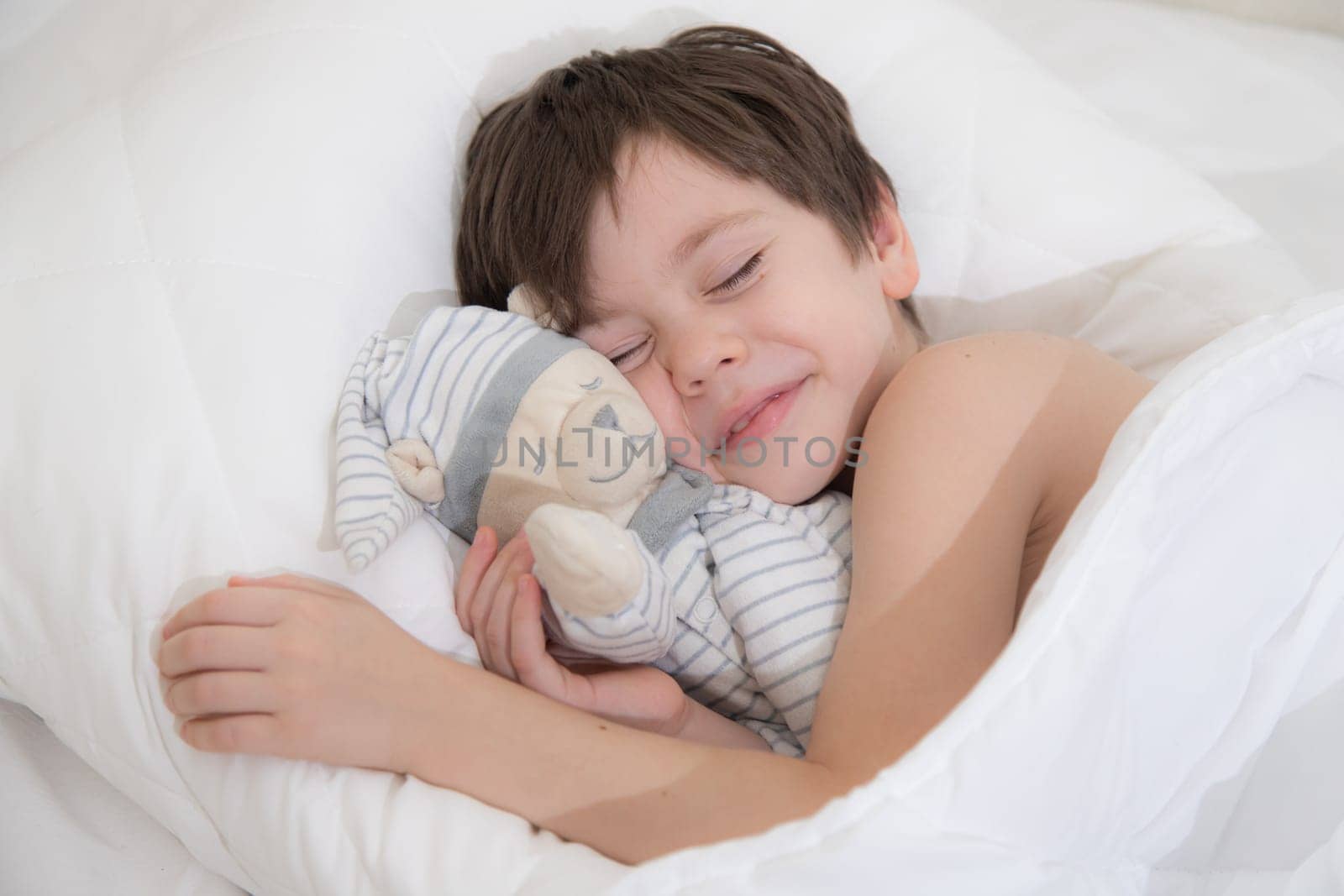 The child is sleeping sweetly in his bed . Sweet baby's dream. The child is in bed . An article about children's dreams. Boy