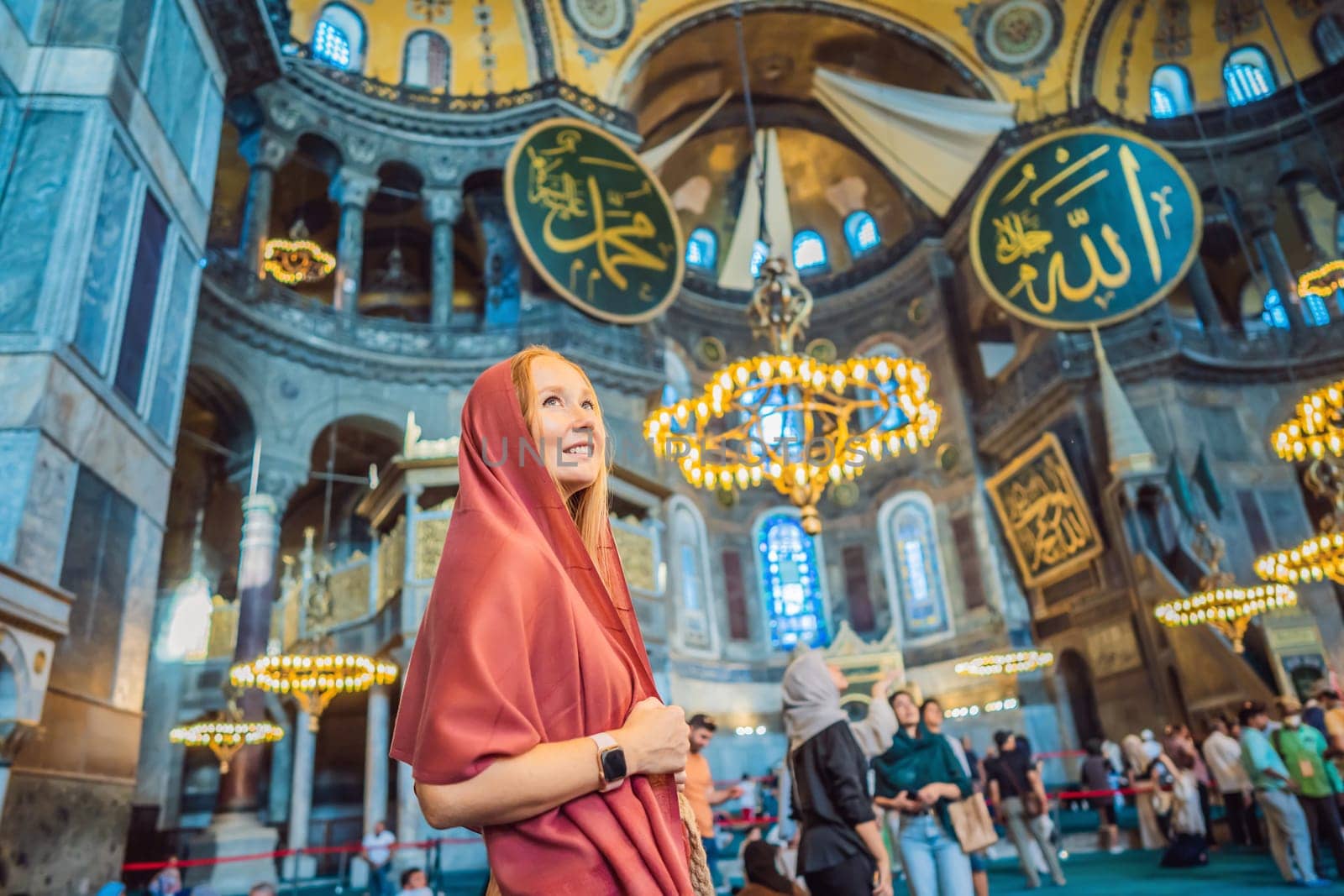 INSCRIPTION - denoting the names of Allah, the Prophet Muhammad, as well as the first 4 caliphs Woman tourist enjoying Hagia Sofia, Ayasofya interior in Istanbul, Turkey, Byzantine architecture, city landmark and architectural world wonder. Turkiye.