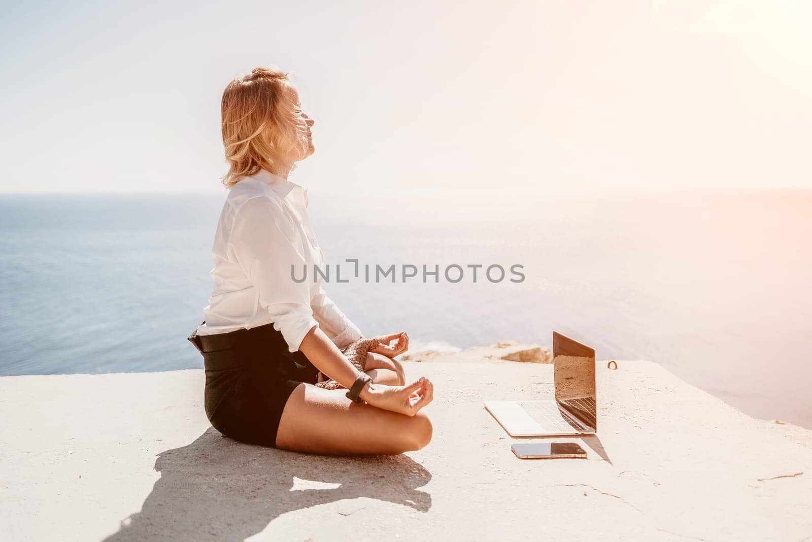 Woman sea laptop yoga. Business woman freelancer in yoga pose working over blue sea beach at laptop and meditates. Girl relieves stress from work. Freelance, digital nomad, travel and holidays concept by panophotograph