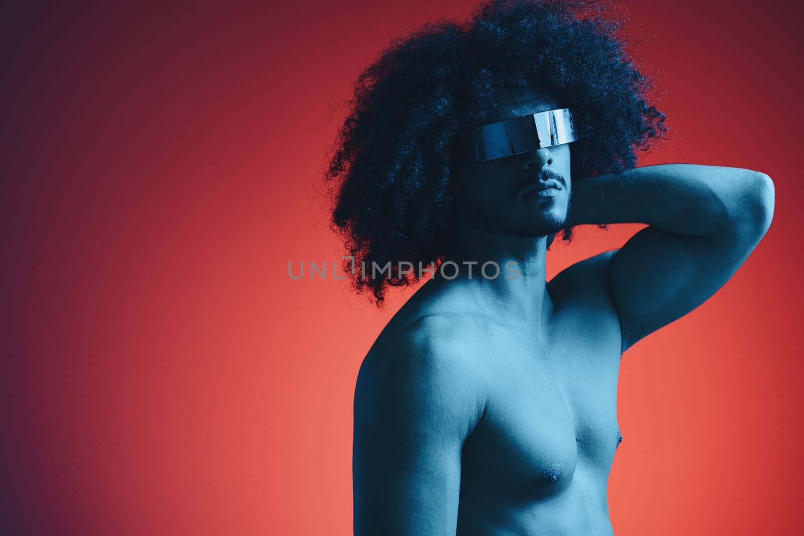 Portrait of fashion man with curly hair on red background with stylish glasses, multinational, colored light, black leather jacket trend, modern concept, sexy body. by SHOTPRIME