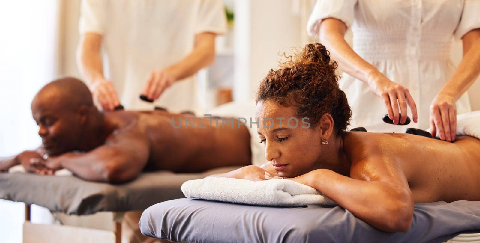 Couple massage, rock or spa therapist for relax, luxury or wellness treatment for health, self care or zen at resort. Healthcare, beauty salon or black woman and man for healthy, skincare or therapy by YuriArcurs