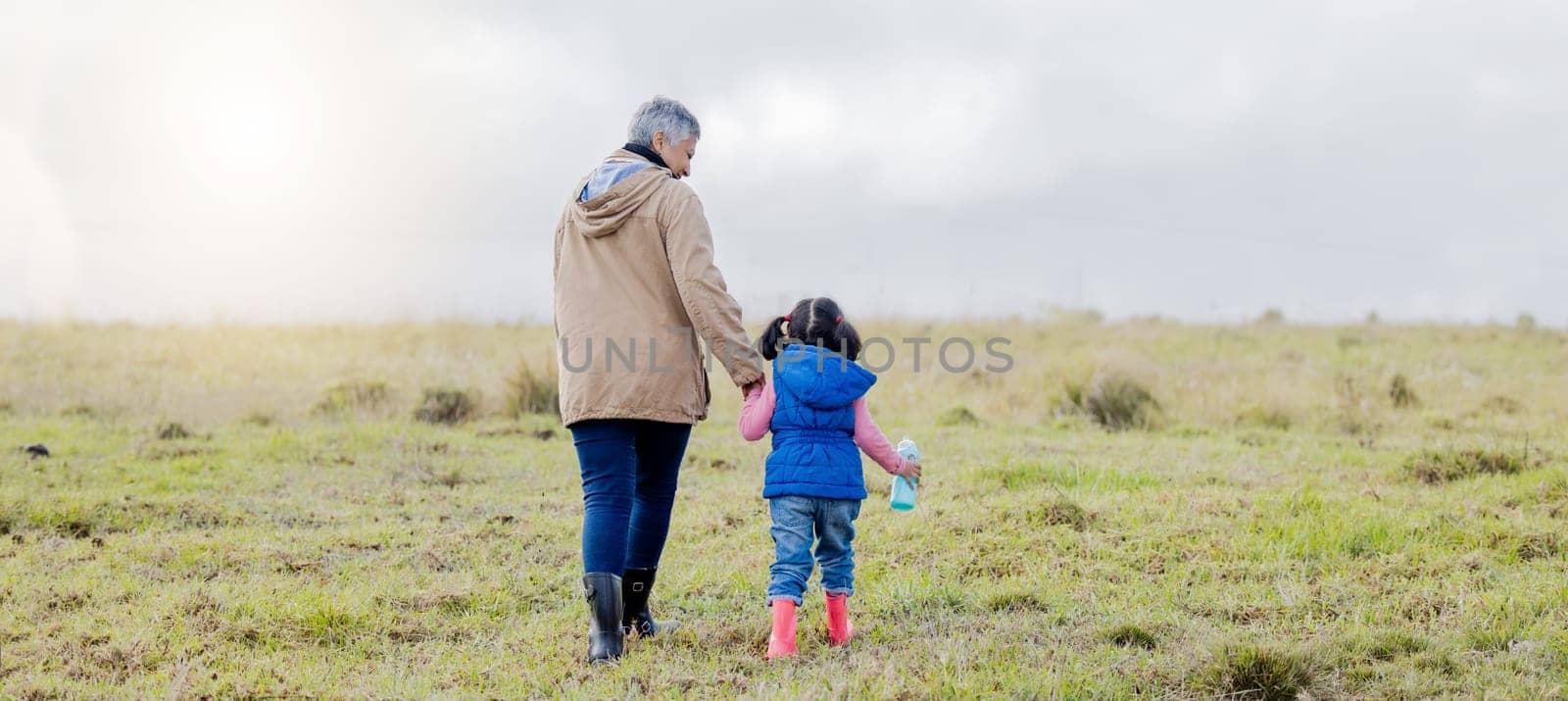 Back, love and grandmother with girl, countryside and bonding together, happiness and loving. Family, granny and granddaughter in nature, morning and walking for fresh air, balance and affection by YuriArcurs