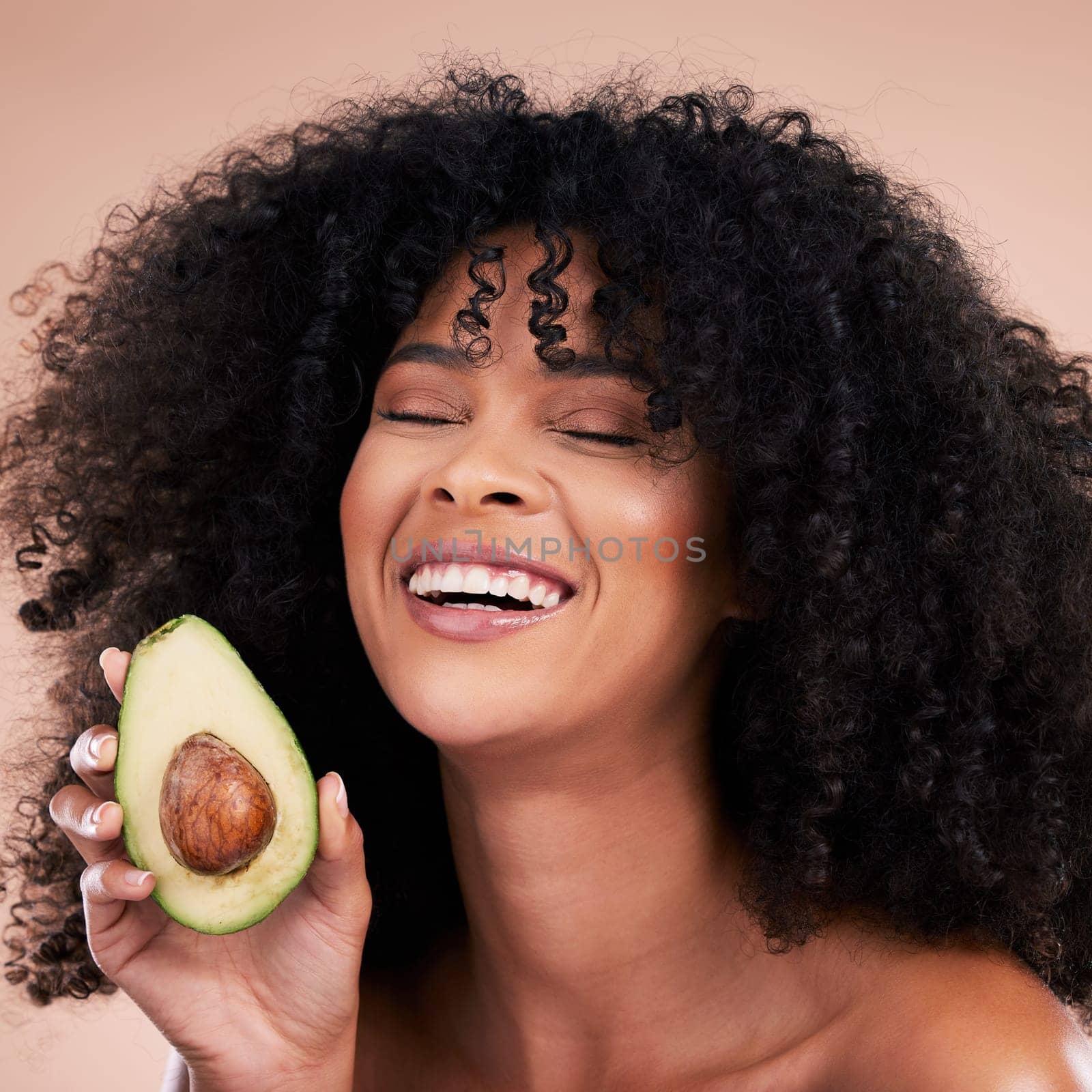 Black woman, studio and avocado for beauty, smile and skincare with health, wellness and self care by background. Happy gen z model, african and fruit for natural aesthetic, healthy nutrition or diet.