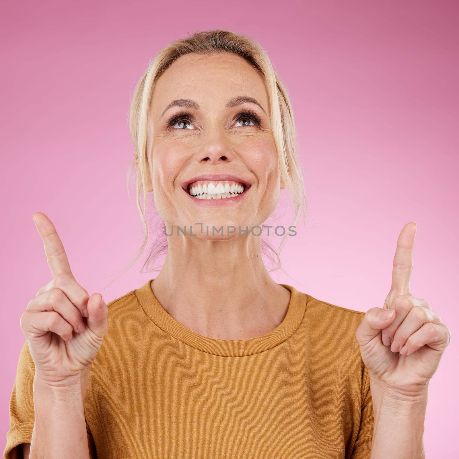 Mockup, woman and pointing on pink background, studio offer and advertising space. Happy female model, marketing and product placement of promotion, announcement and commercial mockup, news or review.