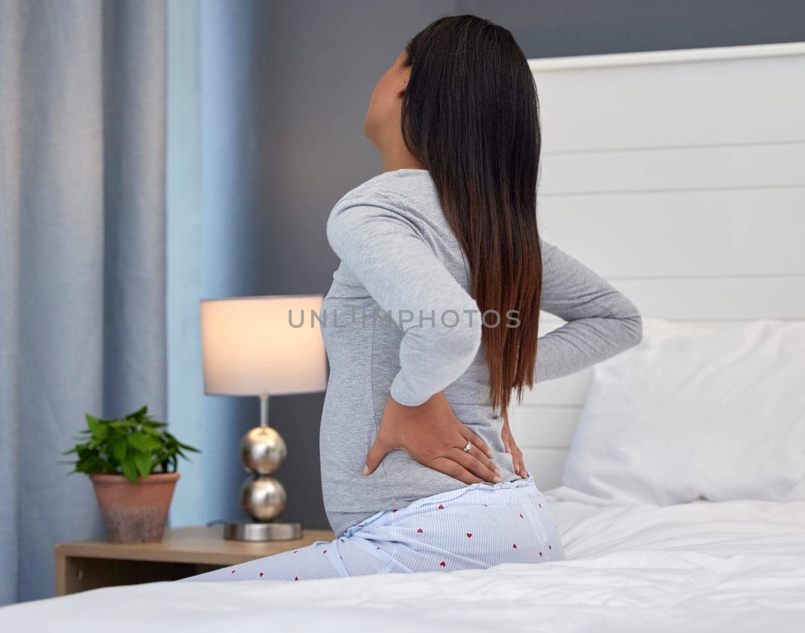 Tired, burnout and pregnant woman with back pain on a bed for rest, injury and fatigue. Healthcare, stress and girl with backache during pregnancy in her bedroom with morning sickness and cramps by YuriArcurs
