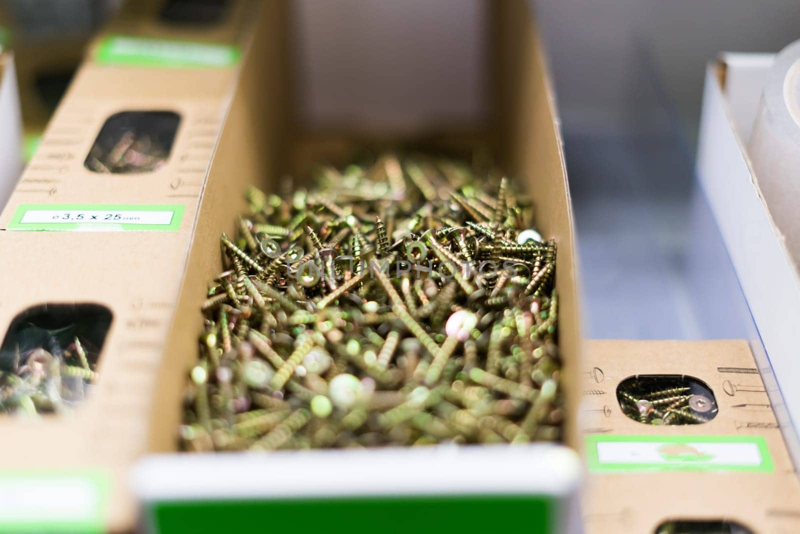 Small thin metal nails, hardware, screw lying in a store container. by Zelenin