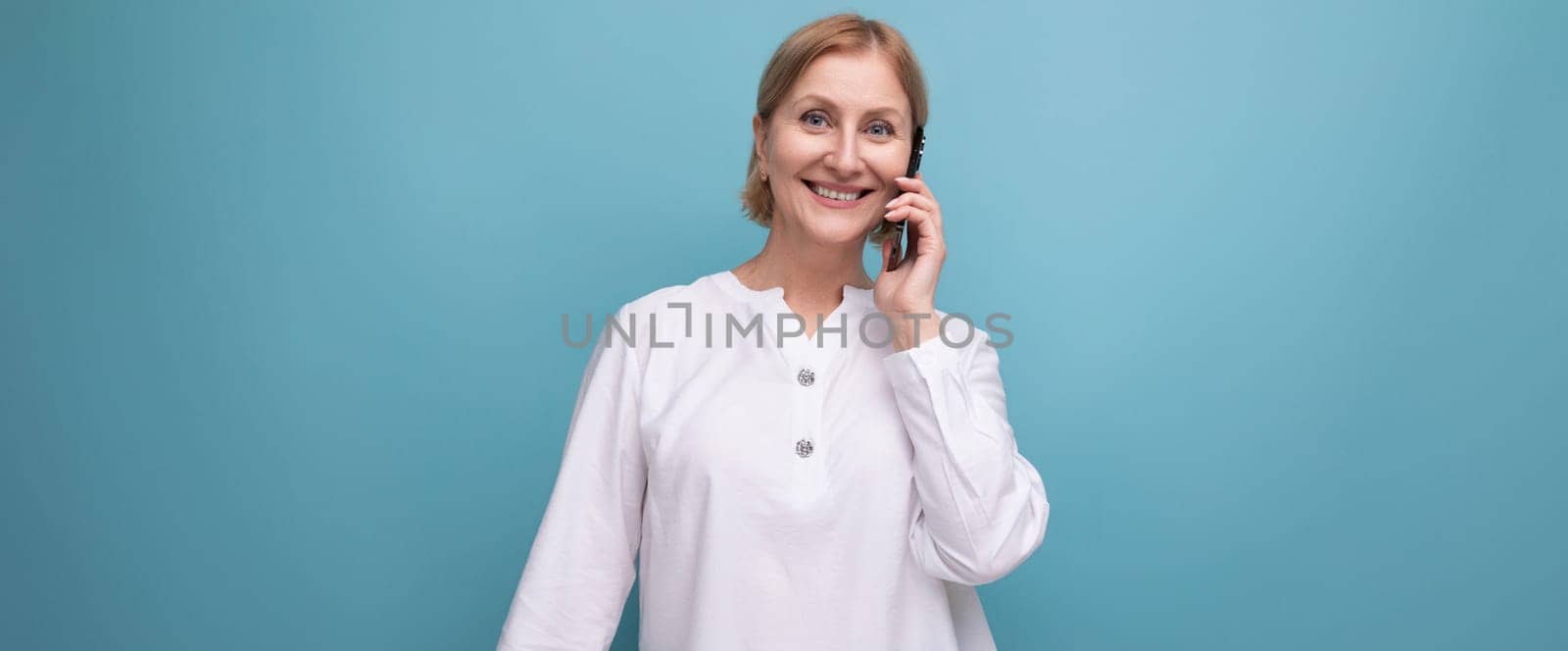 happy blond middle aged woman in white blouse.