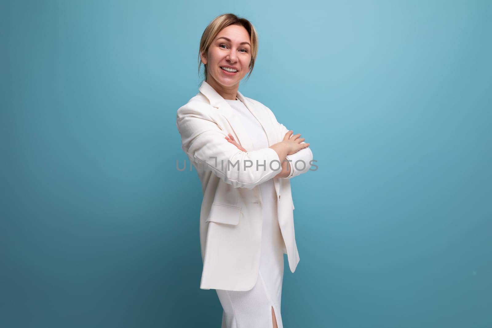 young well-groomed slender blond woman wearing a white jacket and dress by TRMK