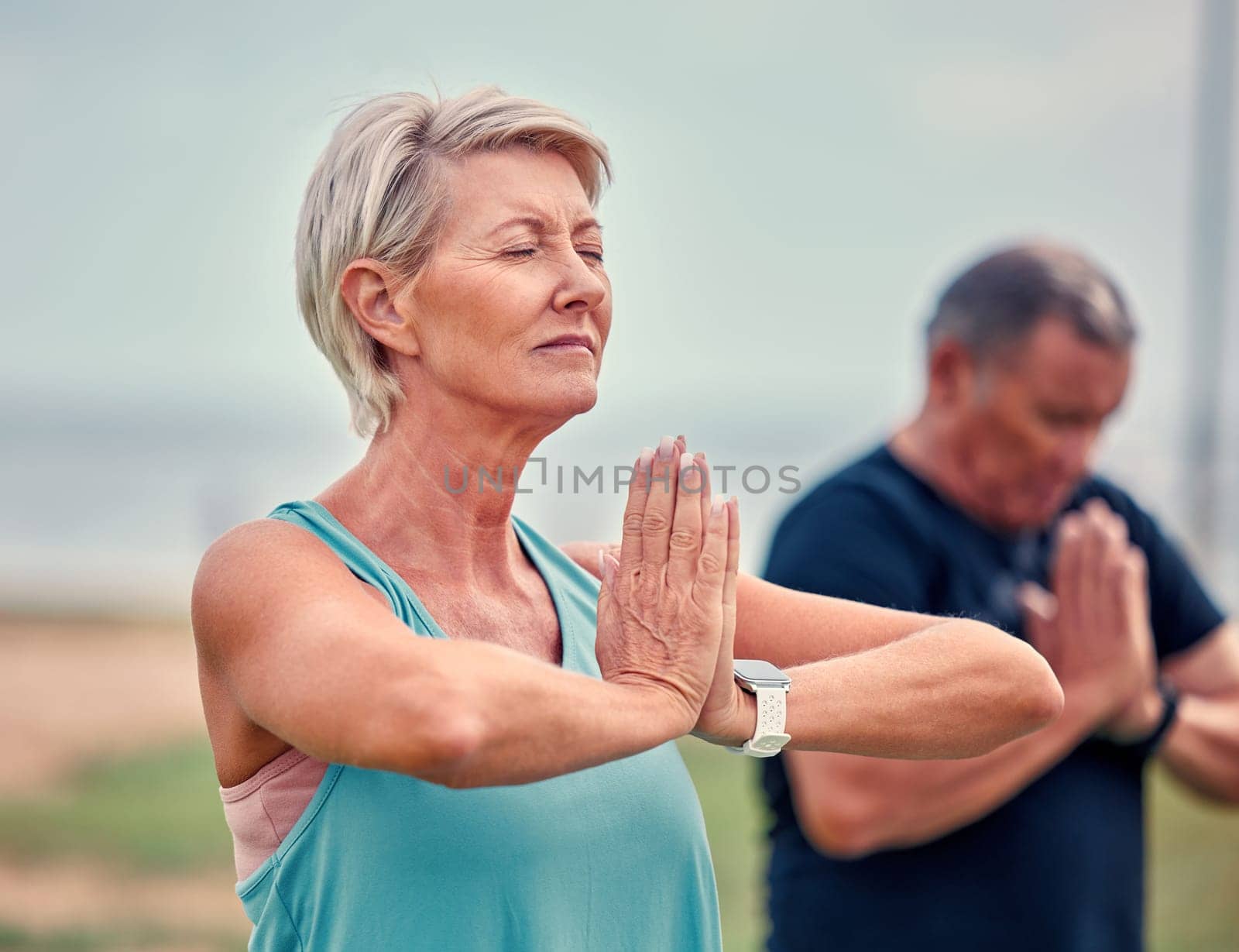 Yoga, fitness and senior woman in praying hands for spiritual wellness, holistic meditation or retirement health. Calm mind, prayer and elderly couple or personal trainer meditate, namaste and peace by YuriArcurs