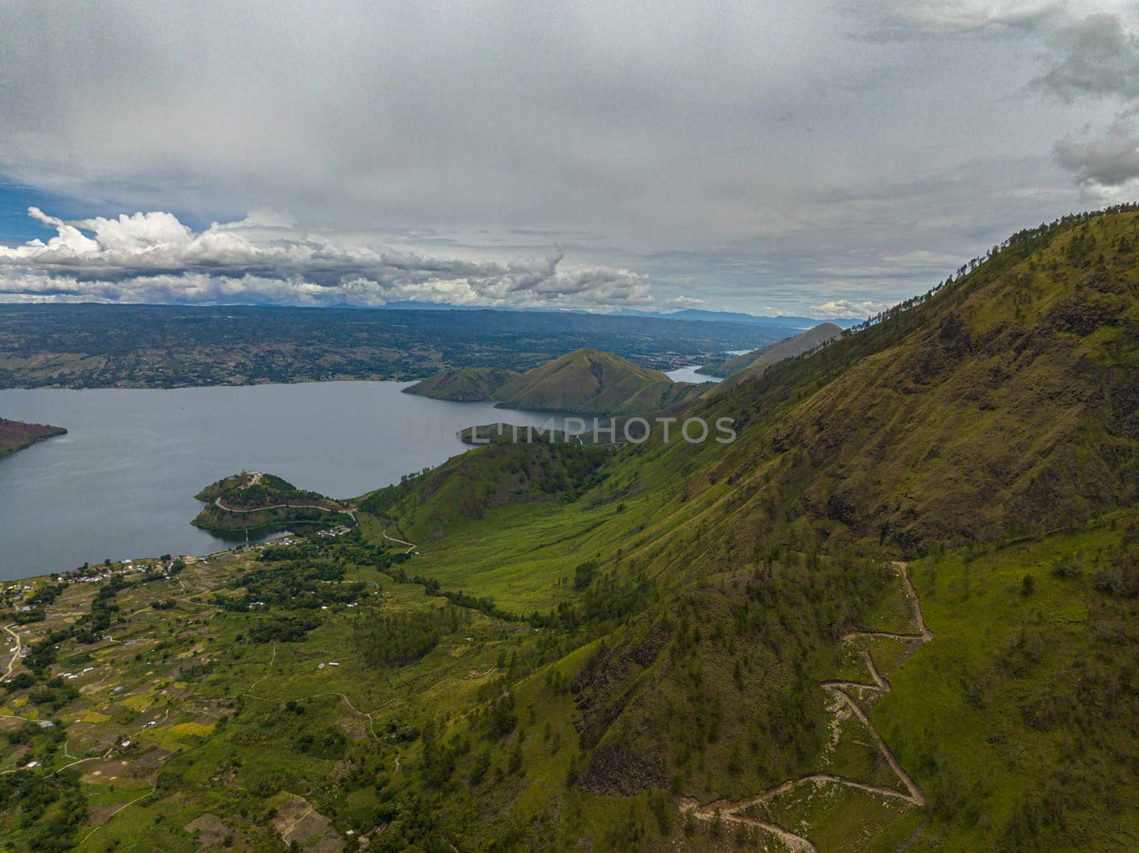 Aerial drone of mountains with forest and Lake Toba. Samosir Island. Sumatra, Indonesia.