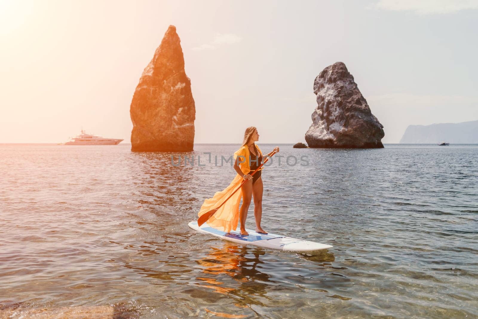 Woman sea sup. Close up portrait of happy young caucasian woman with long hair looking at camera and smiling. Cute woman portrait in bikini posing on sup board in the sea by panophotograph