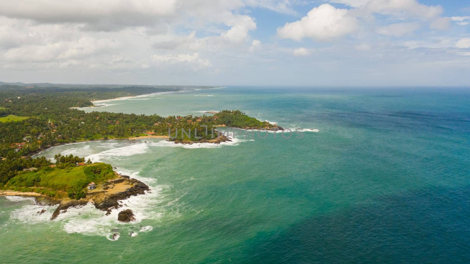 The coastline with hotels, palm trees and ocean surf. Travel concept. Sri Lanka.