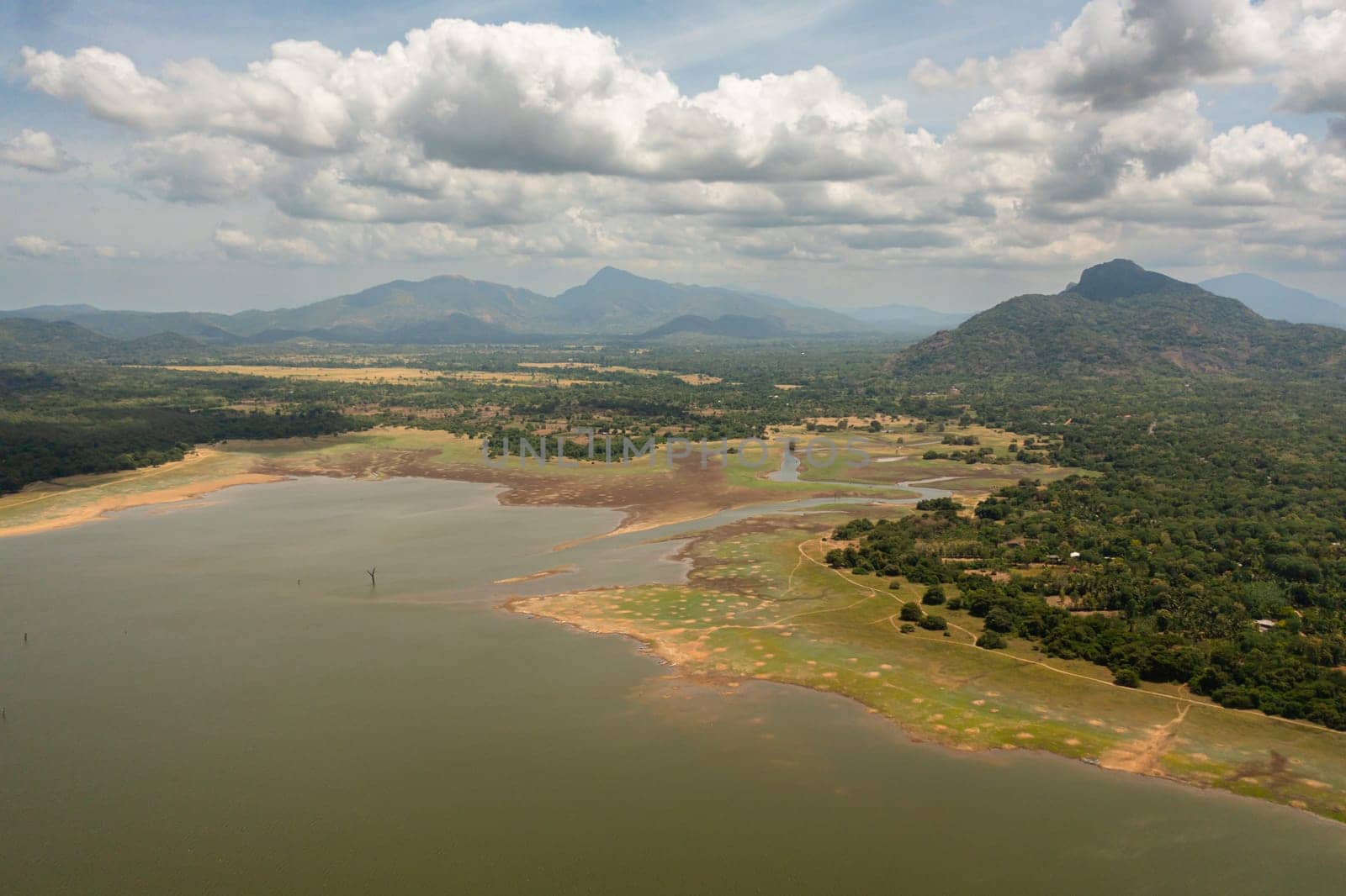 Aerial view of lake in a valley among tropical vegetation. Kandalama Reservoir in Sri Lanka.