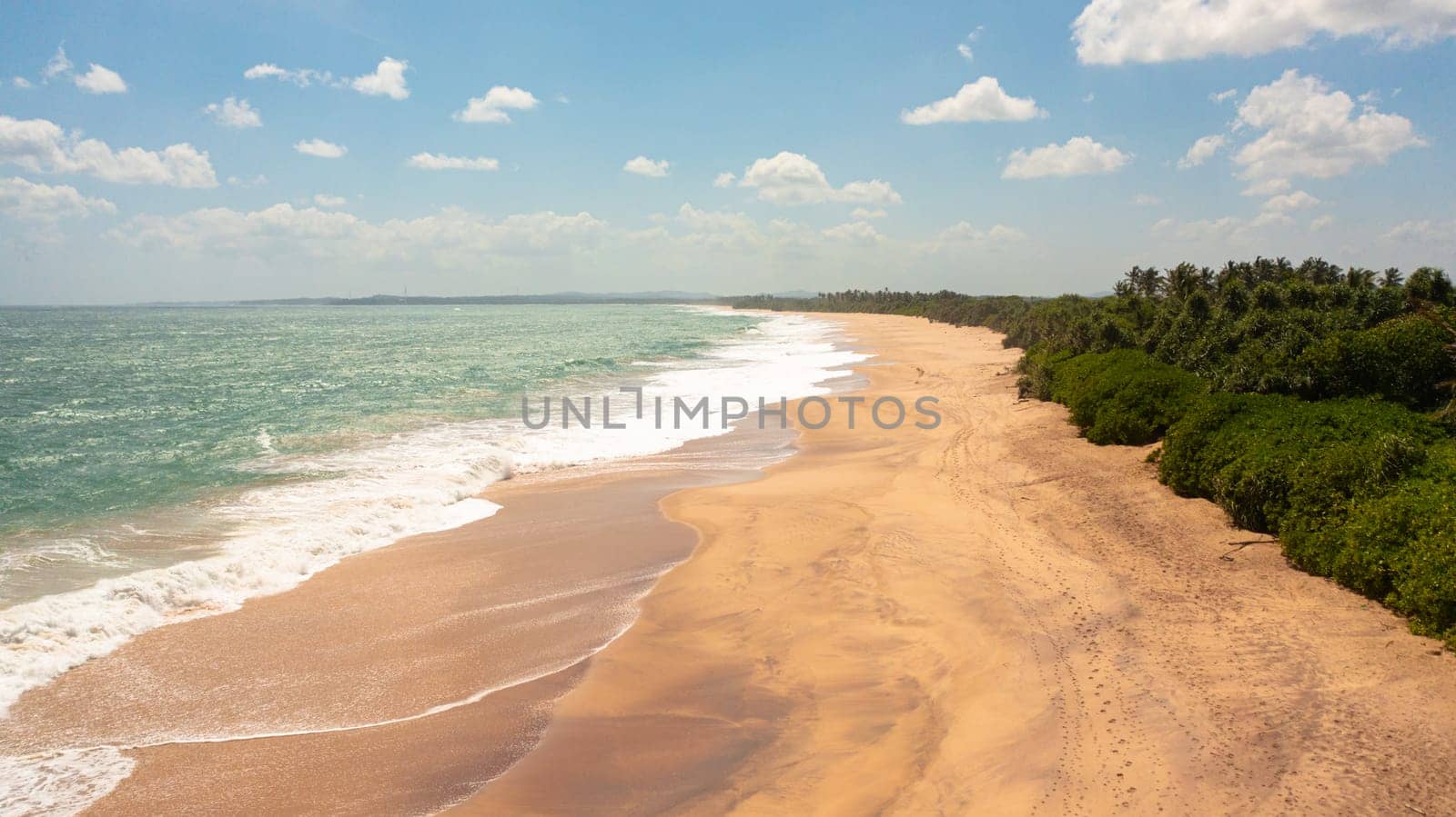 Seascape with tropical sandy beach and blue ocean. Sri Lanka.