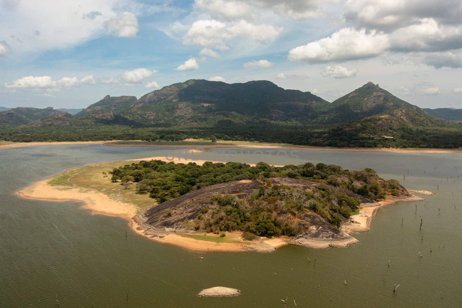 Aerial view of island and a lake in the jungle in a mountain valley. Kandalama Reservoir in Sri Lanka.
