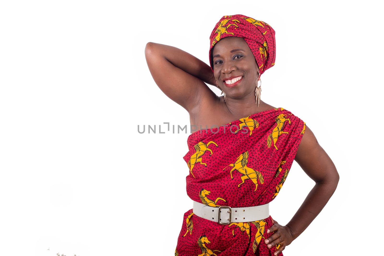 young woman standing in loincloth in a studio looking at camera smiling.