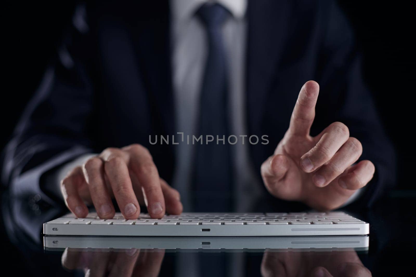 man in suit typing on the keyboard with care
