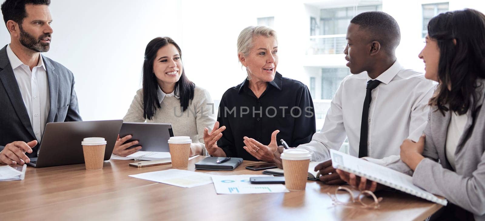 Business people, meeting and professional team talking in a corporate office for brainstorming. Diversity men and women at a table for planning, discussion and strategy with technology and ideas.