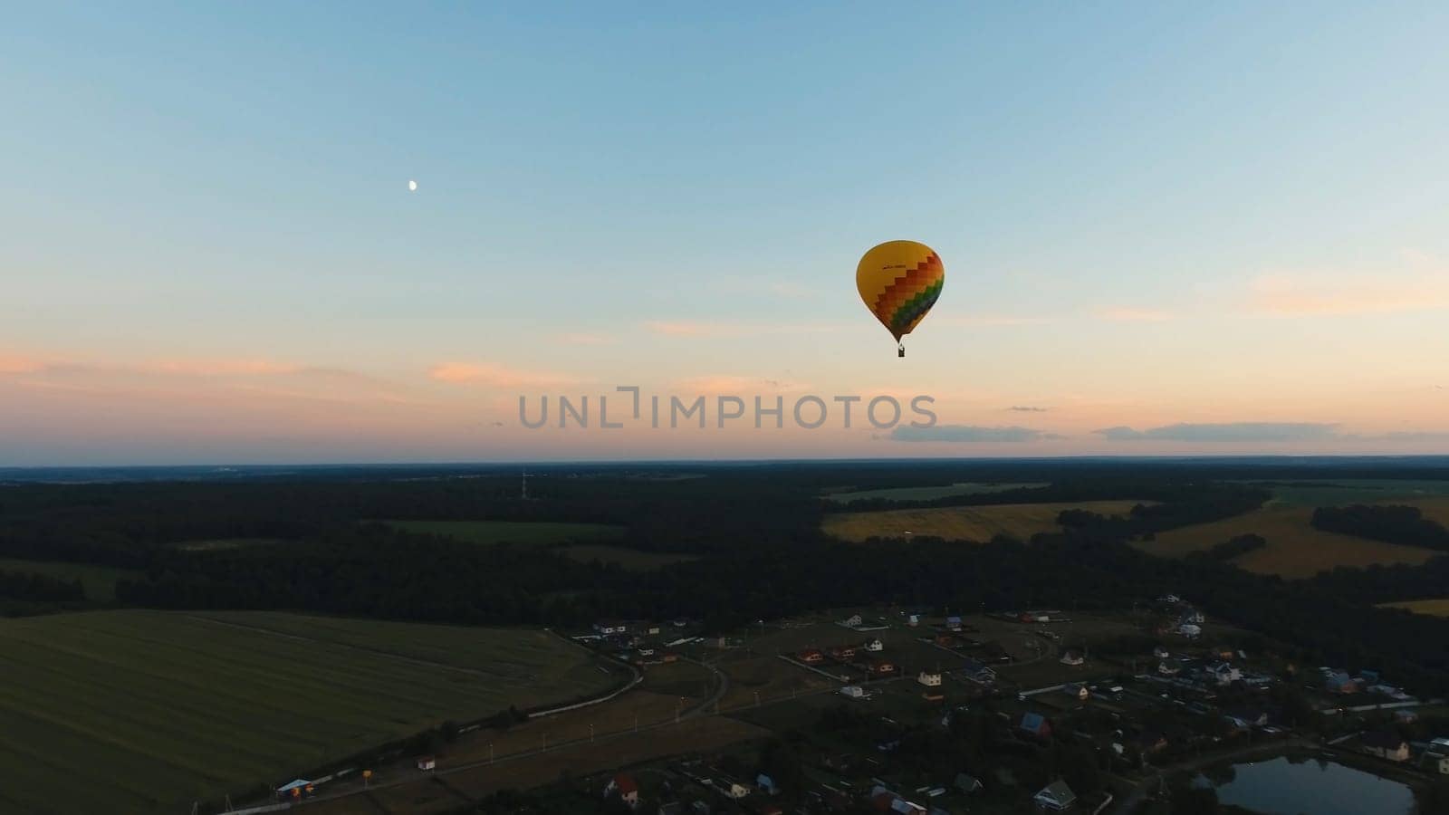 Aerial view Hot air balloon in the sky over a field in the countryside in the beautiful sky and sunset. Balloon silhouette with sunrise, Aerostat fly in the countryside.