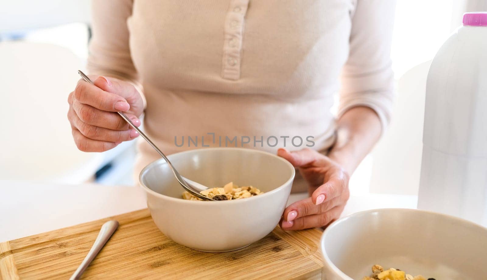 Girl eating muesli at breakfast at the kitchen