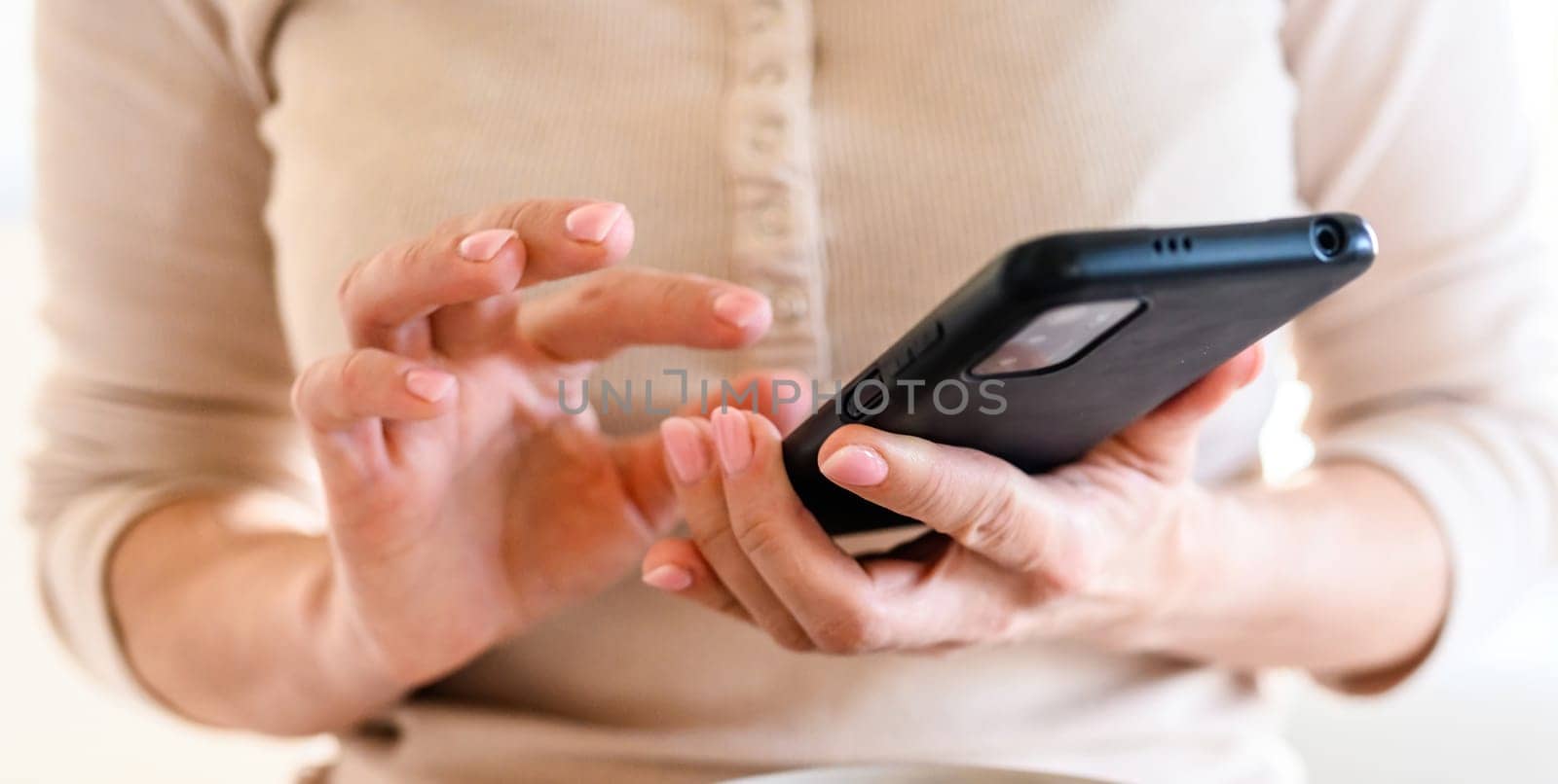 Girl using black smartphone, surfing on the internet.