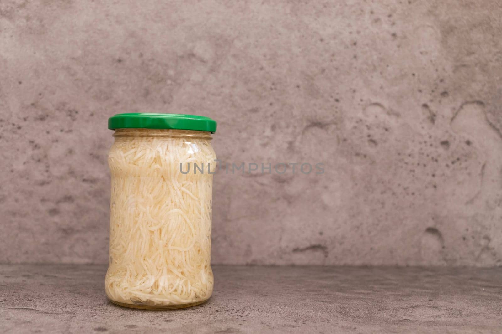 Celery Root Salad Preserve In Glass Jar With Screw Metal Cap On Shelf. Shredded And Pickled Celery Crops, Tuber. Apium Graveolens, Culinary. Vitamins C, K, A, E, PP, B. Copy Space, Horizontal Plane.