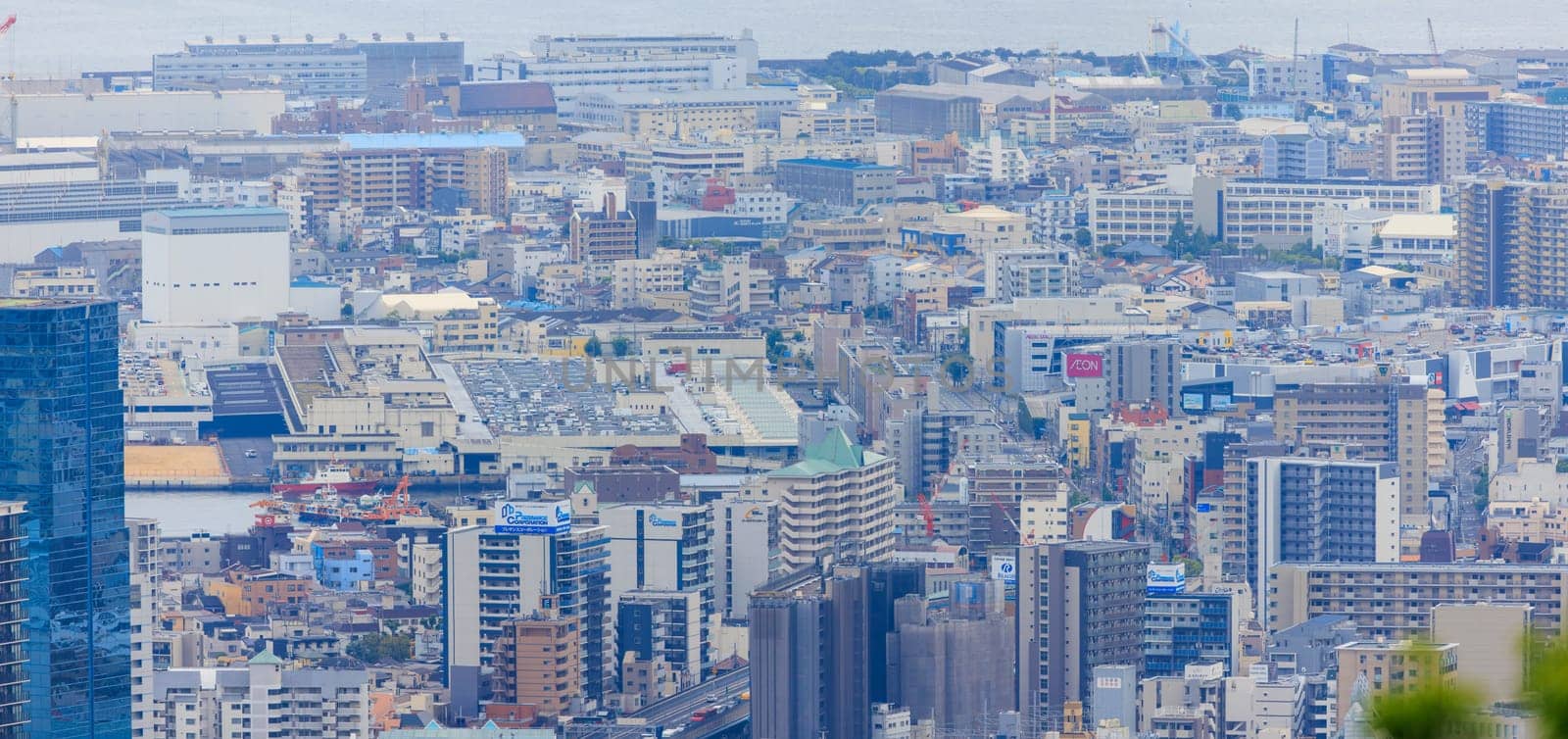 Kobe, Japan - May 20, 2023: Looking down on office buildings and apartments in city center by Osaze