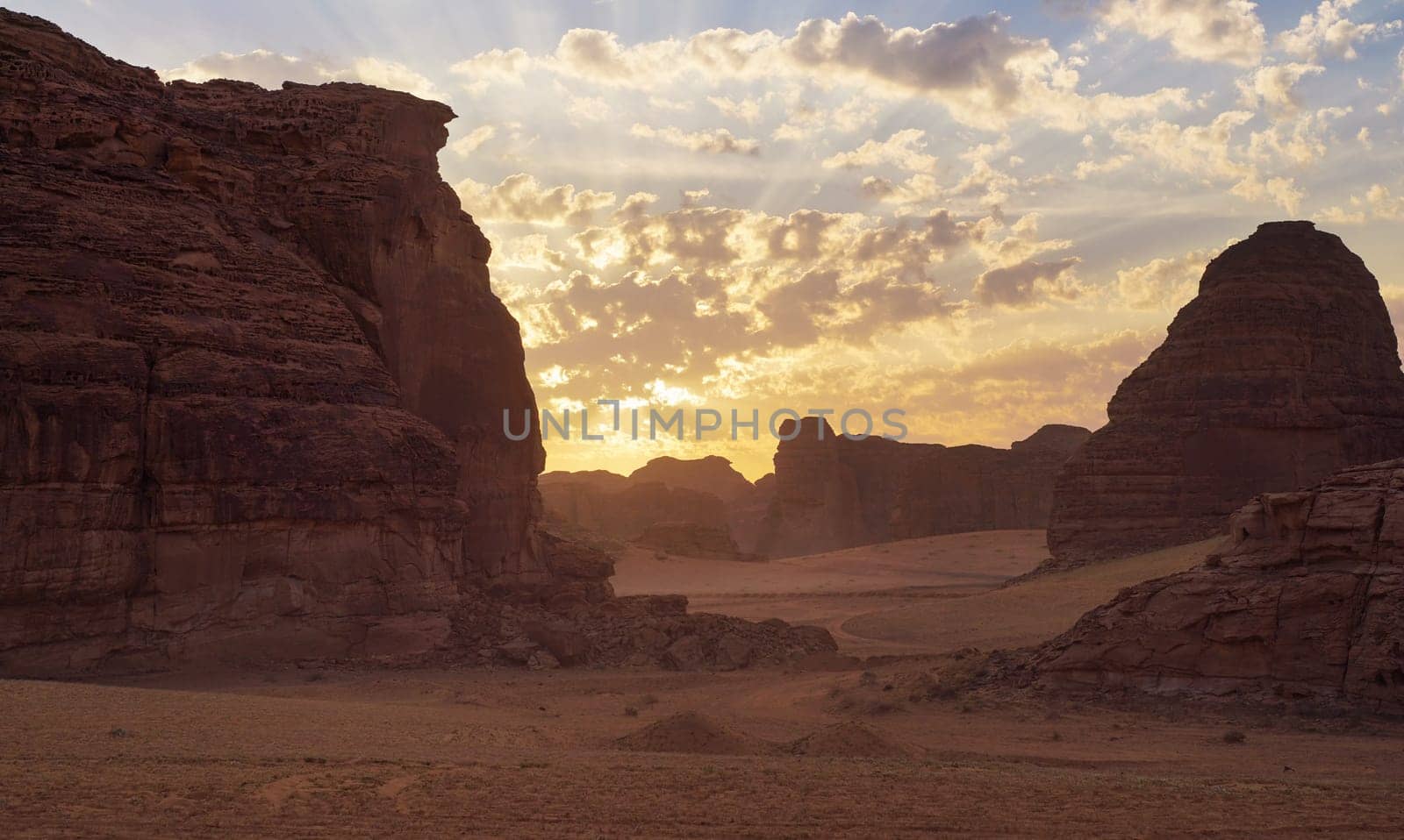 Morning sun shines over rocky desert formations, typical landscape in Al Ula, Saudi Arabia.