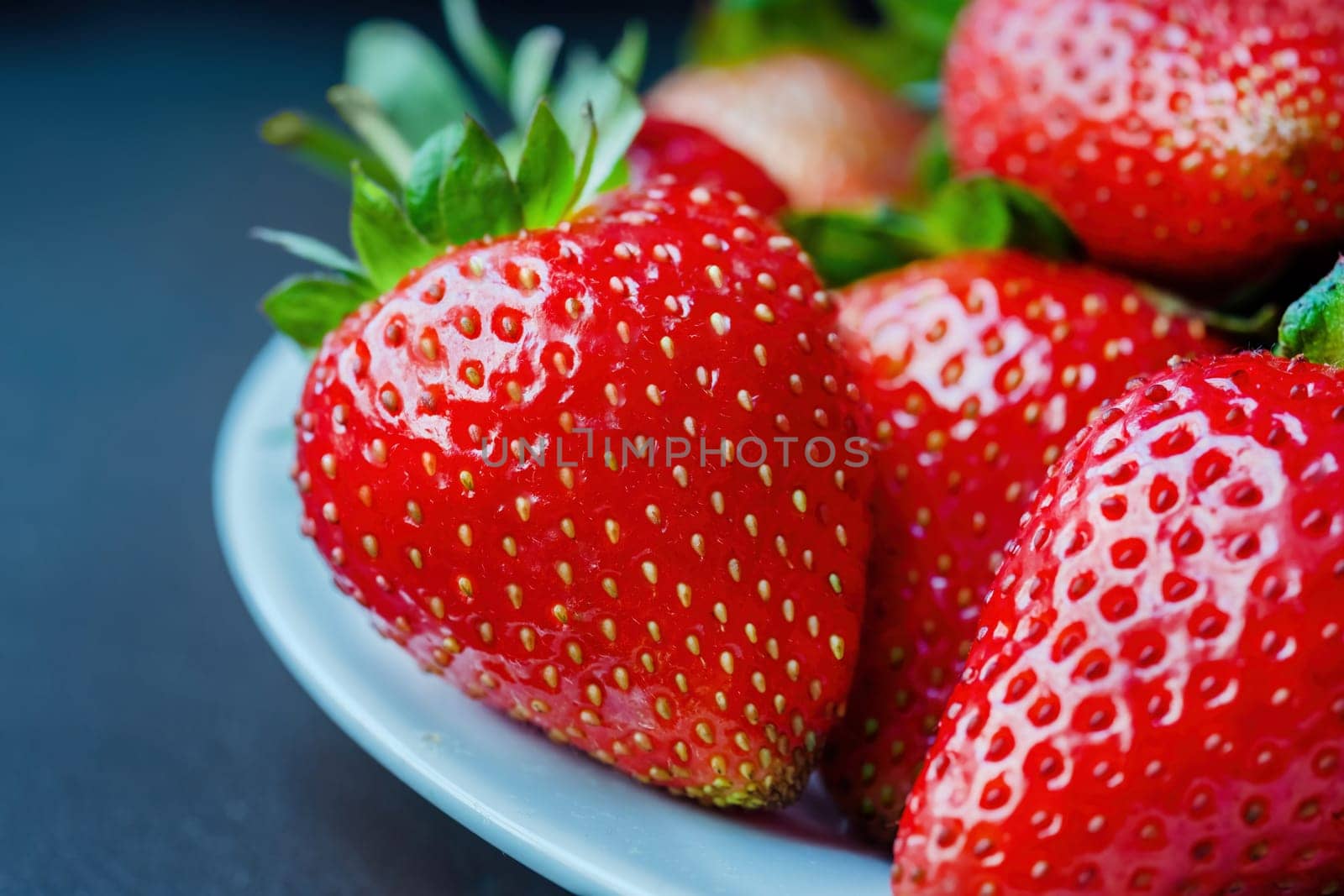 Red Strawberries in a Bowl Ready to Eat. Strawberries laying in heap in white porcelain bowl