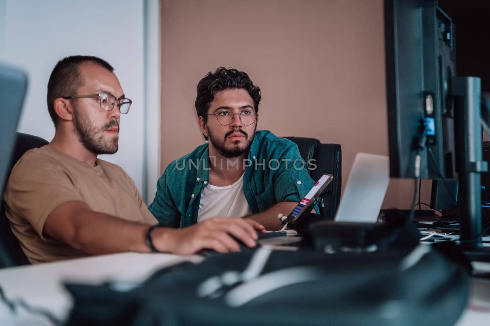 Programmers engrossed in deep collaboration, diligently working together to solve complex problems and develop innovative mobile applications with seamless functionality. by dotshock