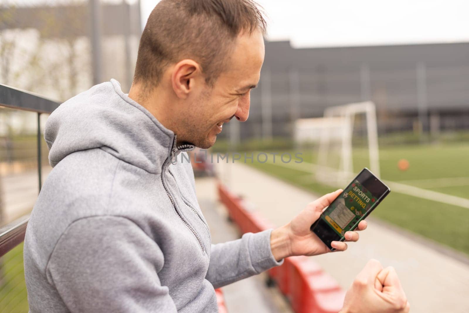 Man using online sports betting services on phone by Andelov13