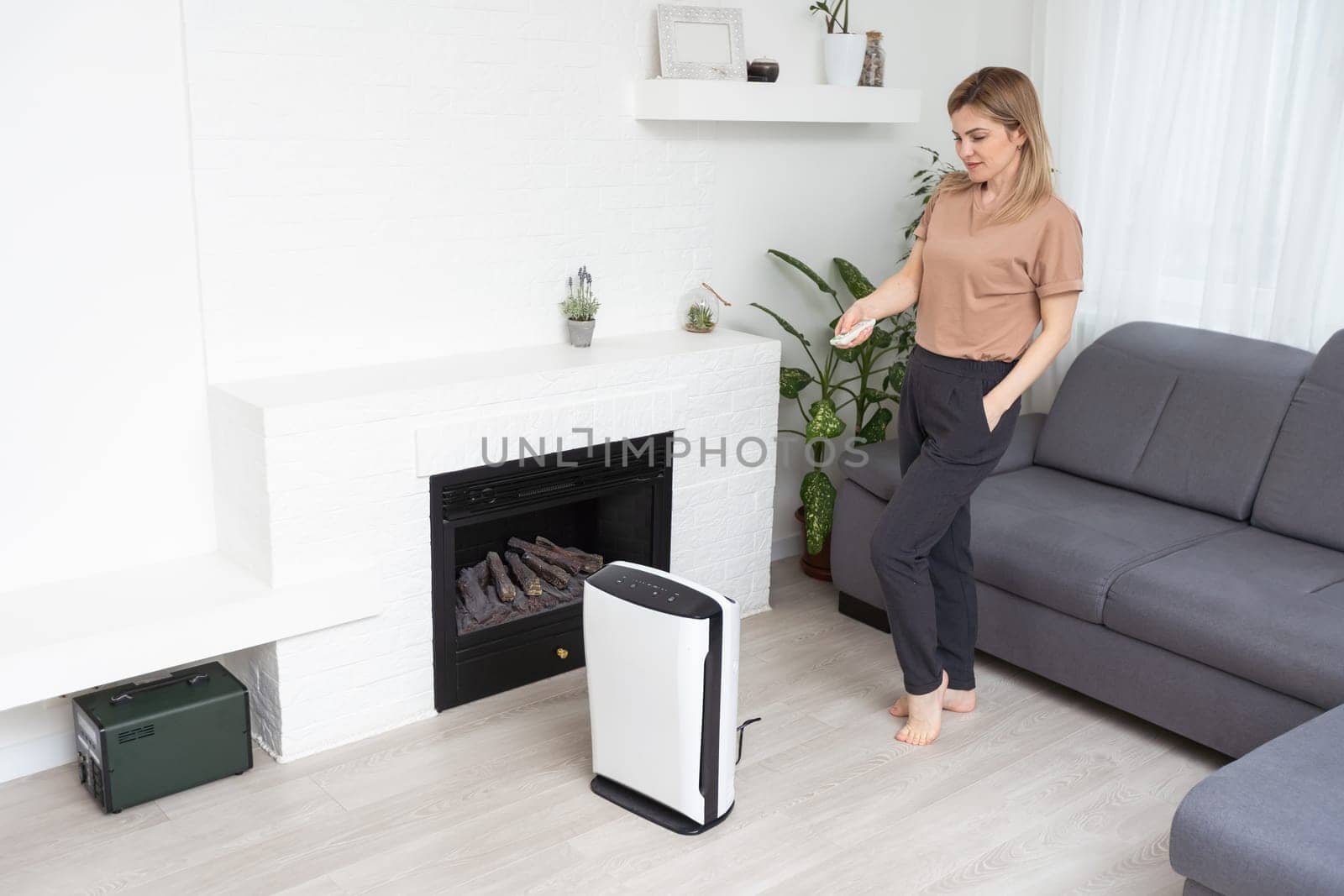 Woman using air purifier, dust filter, clean and health air.