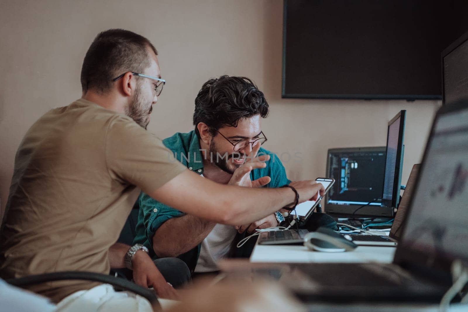 Programmers engrossed in deep collaboration, diligently working together to solve complex problems and develop innovative mobile applications with seamless functionality