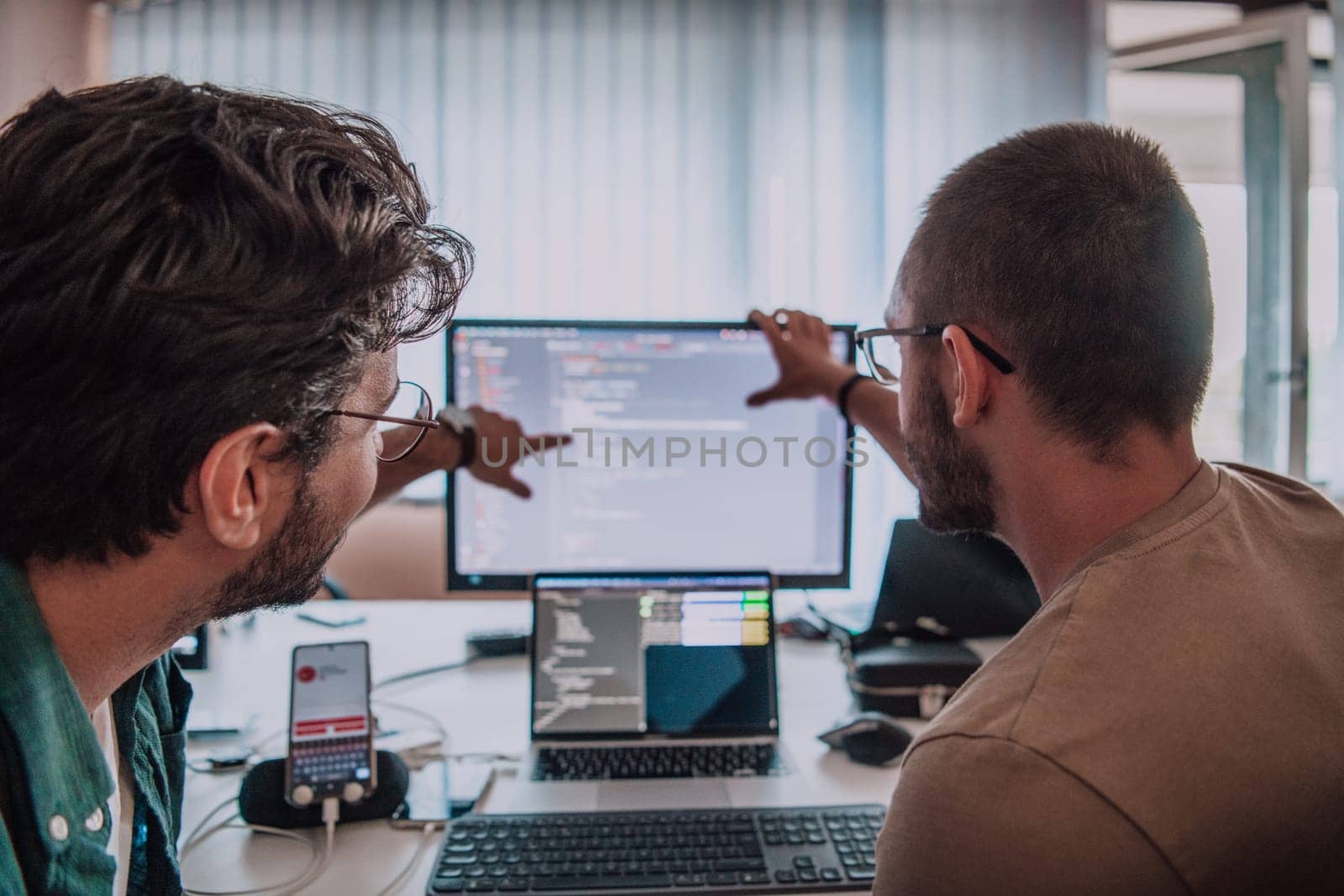 Programmers engrossed in deep collaboration, diligently working together to solve complex problems and develop innovative mobile applications with seamless functionality