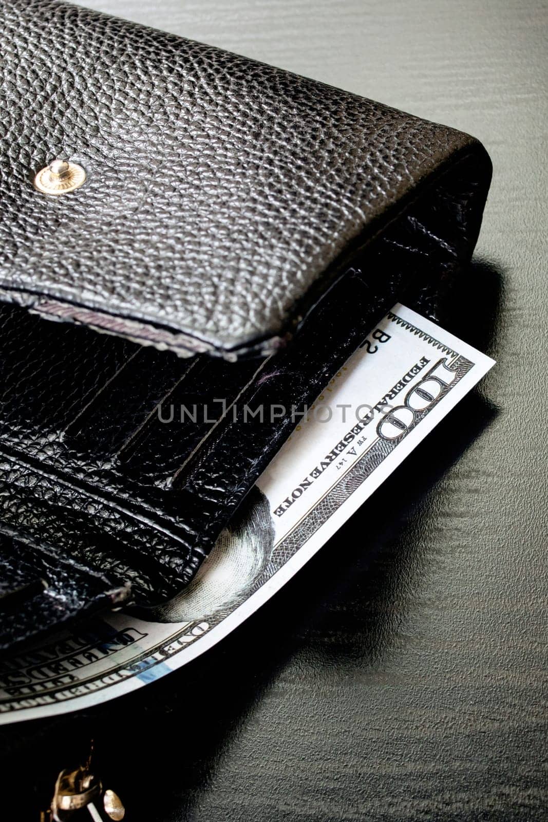 One hundred dollar bill in a black wallet