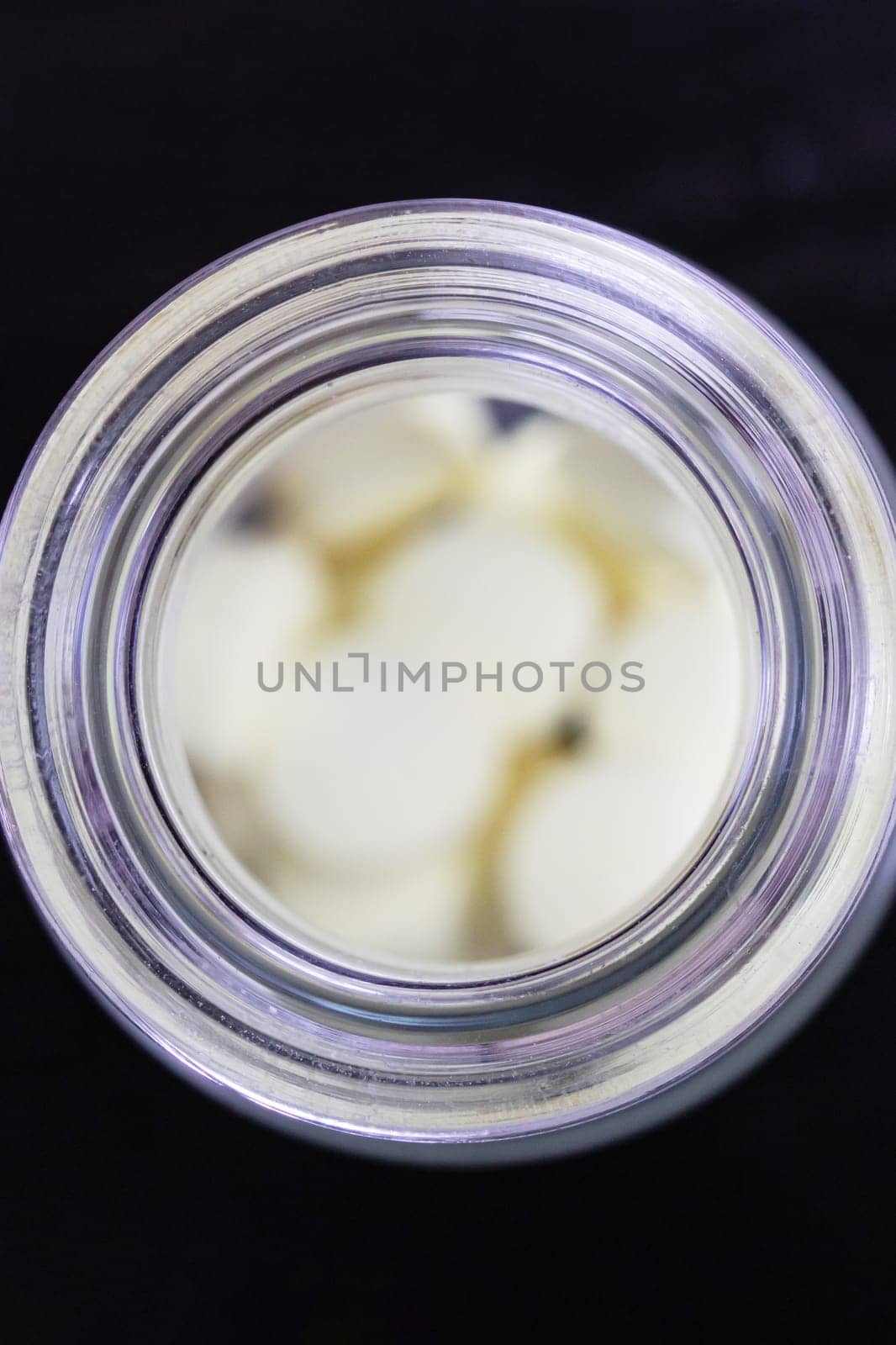 Yellow pills in glass jar on table, top view