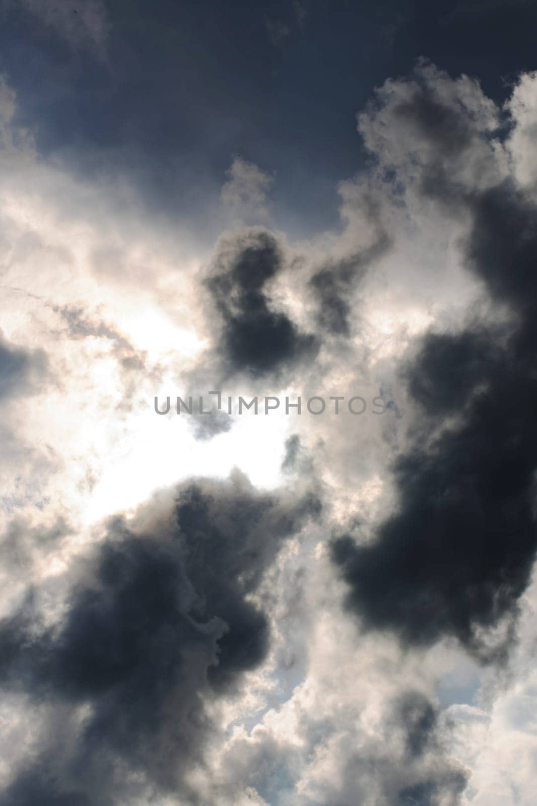 Dark stormy sky with clouds and sunlight, background