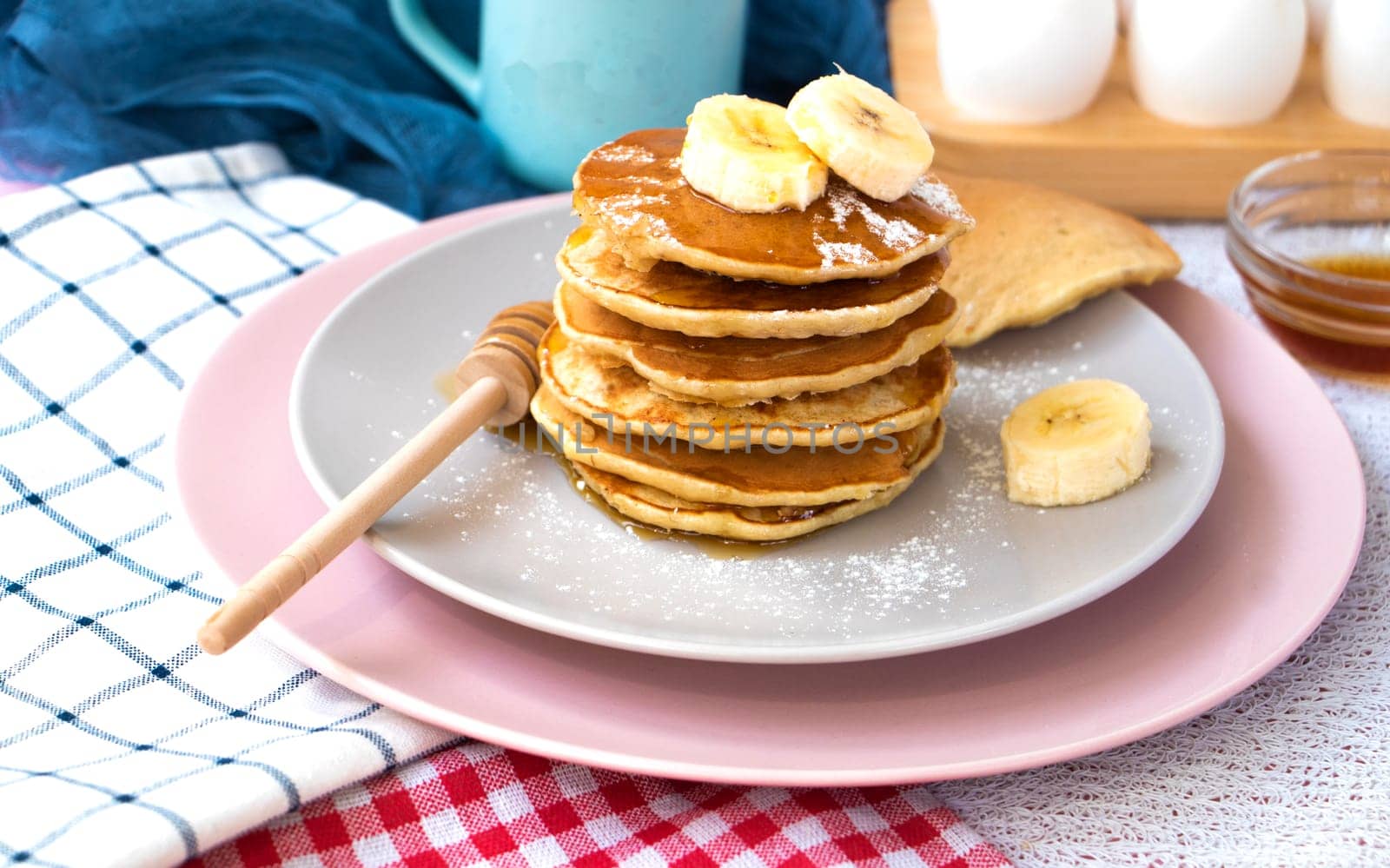 Pour maple syrup over homemade banana cupcakes. A slide of hot cupcakes with fresh bananas on a plate. Maple serop sprouts over cupcakes. Portion of breakfast on a plate. High quality photo