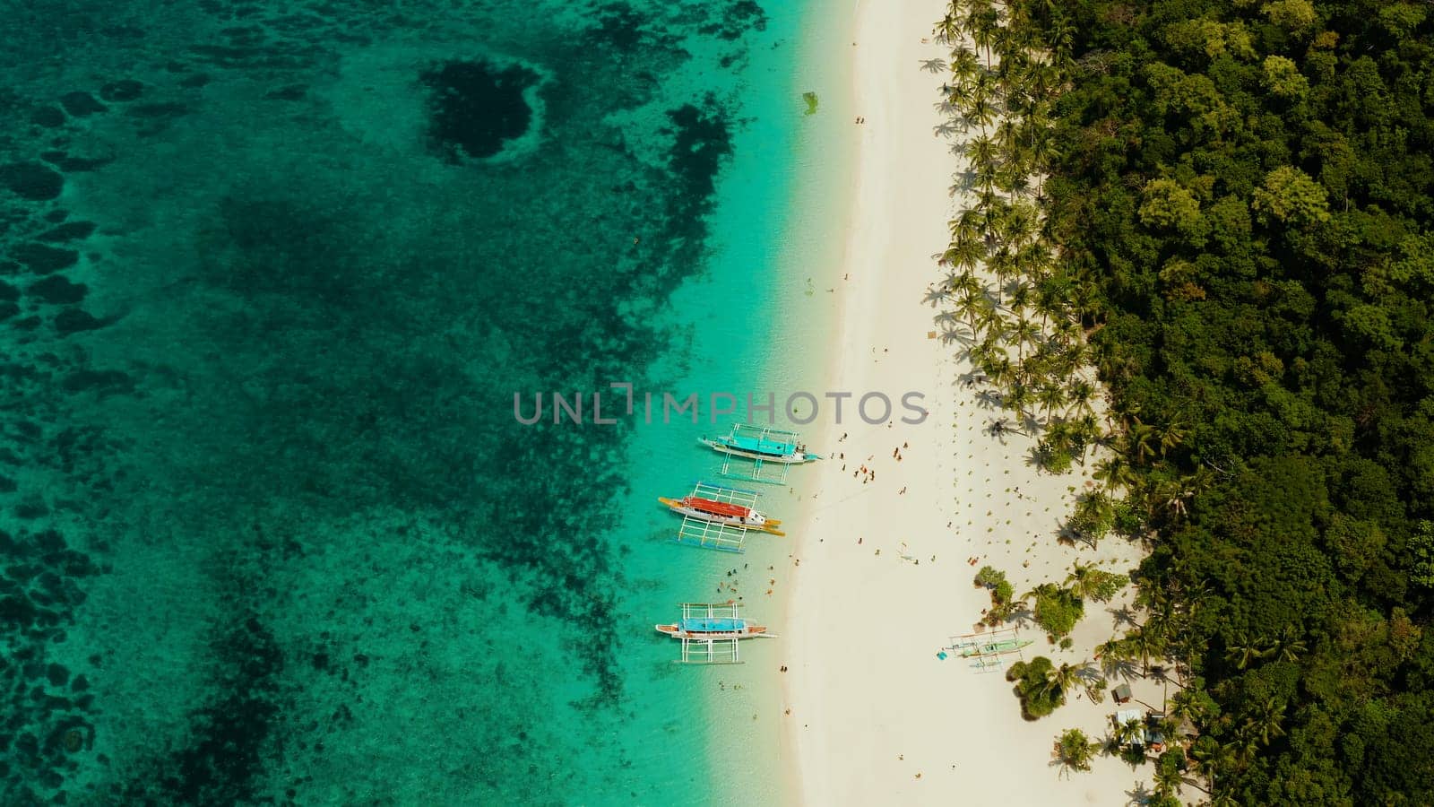 Tropical beach with palm trees and turquoise waters of the coral reef, top view, Puka shell beach. Boracay, Philippines. Seascape with beach on tropical island. Summer and travel vacation concept.